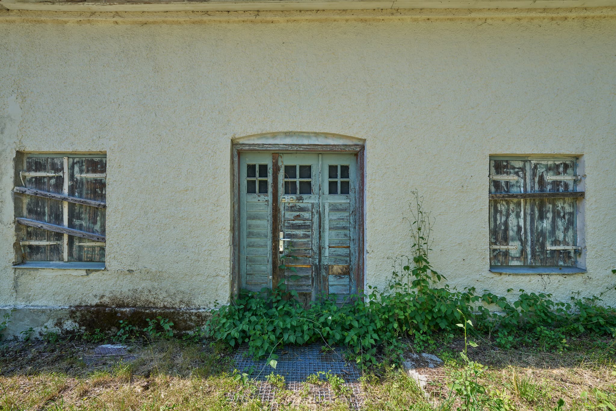 Alte Türe Modeleisenbahnfreunde, Ecksberg, Mühldorf - Alte, verwitterte Holztür eines Gebäudes in Ecksberg, Mühldorf am Inn, Oberbayern. Fenster des Bauwerks sind vernagelt.