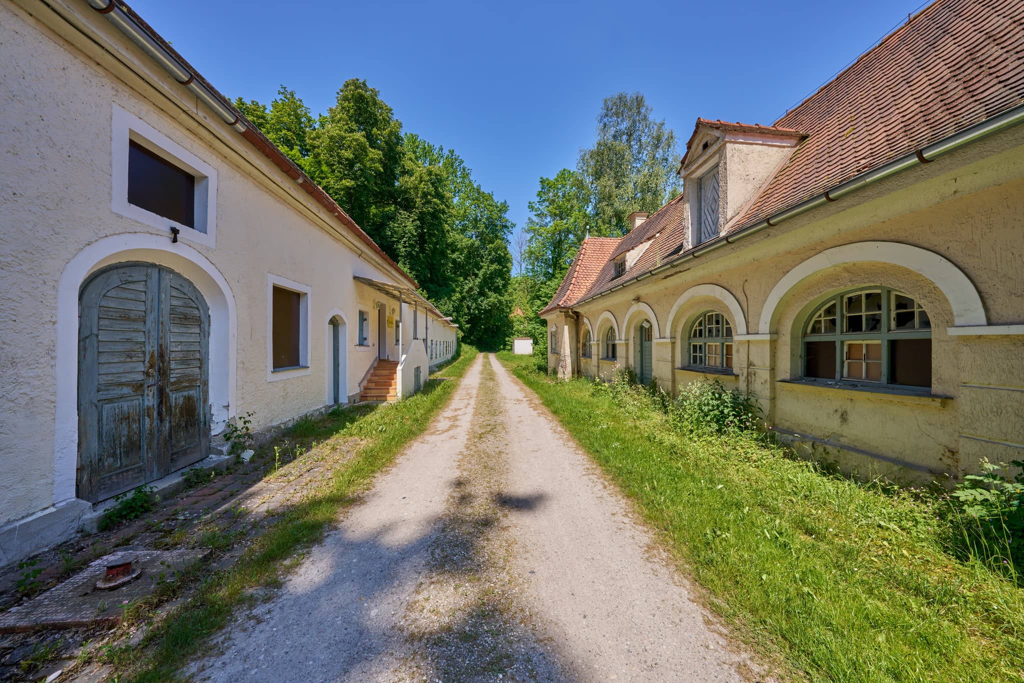 Alte Wäscherei Ecksberg, Mühldorf, Oberbayern, Inn-Salzach - Alte Wäscherei in Ecksberg, Mühldorf am Inn, Oberbayern, Inn-Salzach, Deutschland. Historische Gebäude an einem Schotterweg.