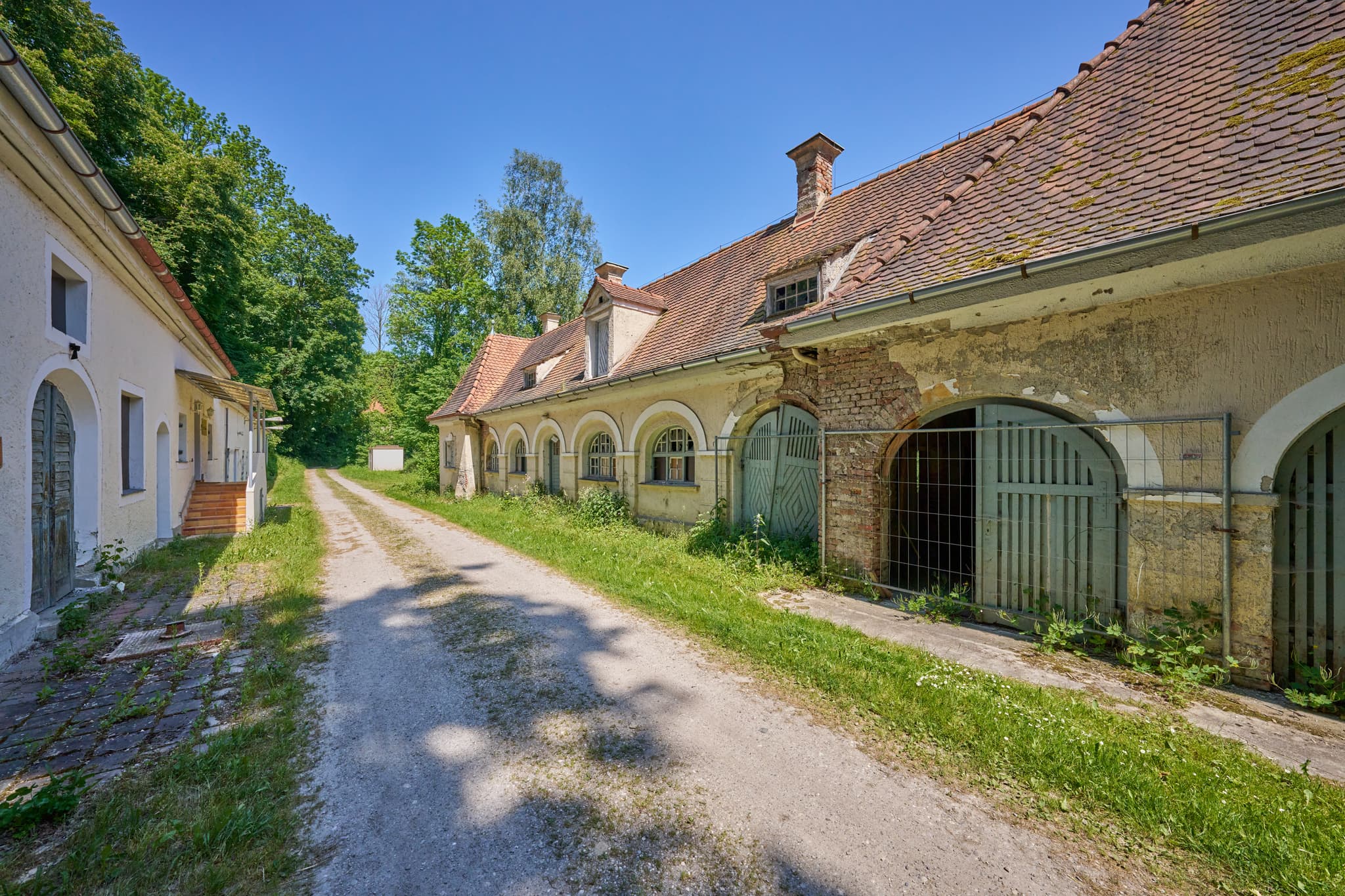 Alte Wäscherei Ecksberg, Mühldorf, Oberbayern, Inn-Salzach - Ansicht der historischen Alten Wäscherei in Ecksberg, Mühldorf. Gebäude an Feldweg, grüne Natur, klarer Himmel.
