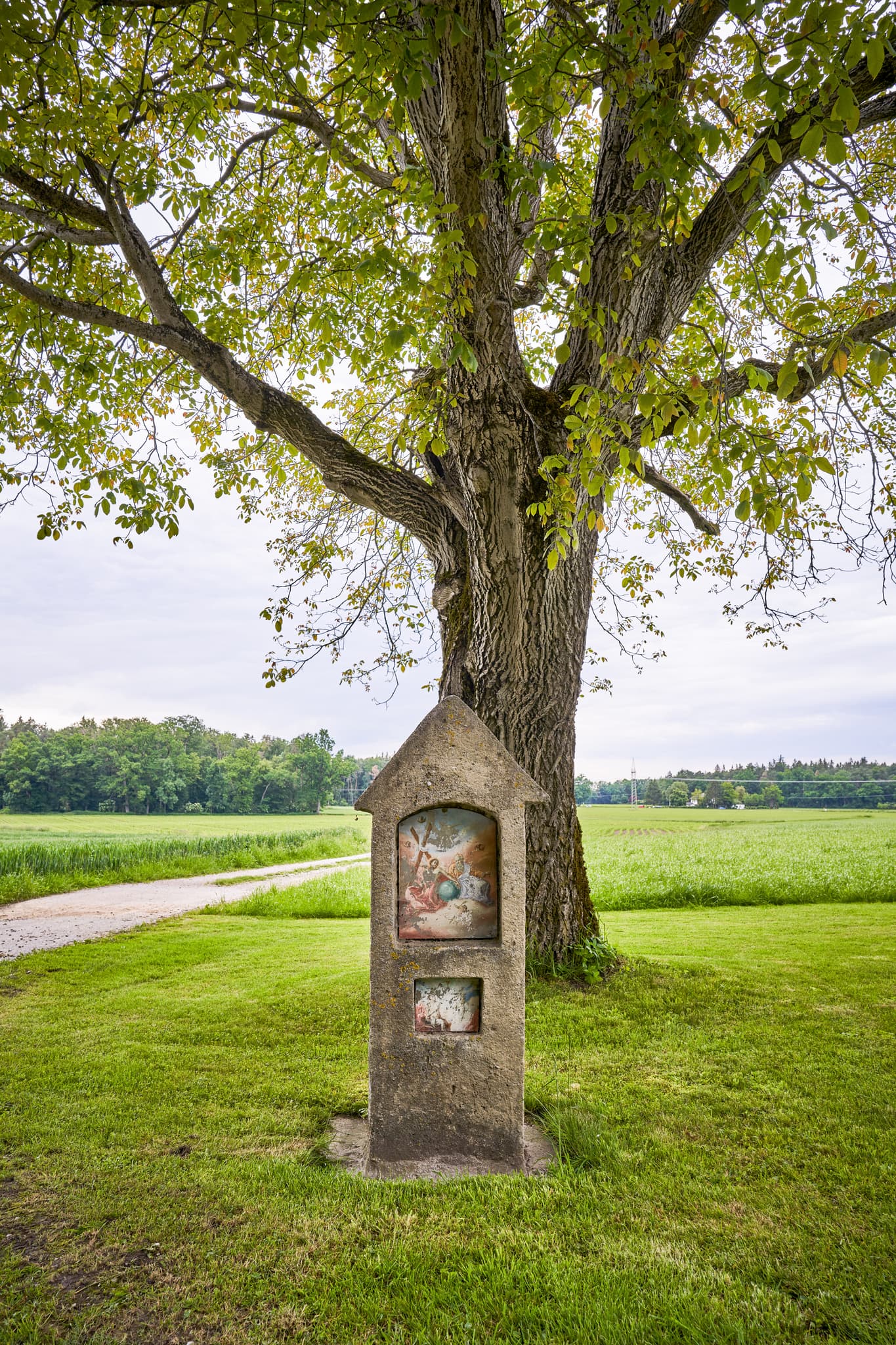 Alter Bildstock, Höresham, Altöttting, Oberbayern - Historischer Bildstock am Feldweg bei Höresham, Burgkirchen, Altötting, Oberbayern. Grüne Wiesen, großer Baum im Hintergrund. Ländliche Schönheit Inn-Salzach.