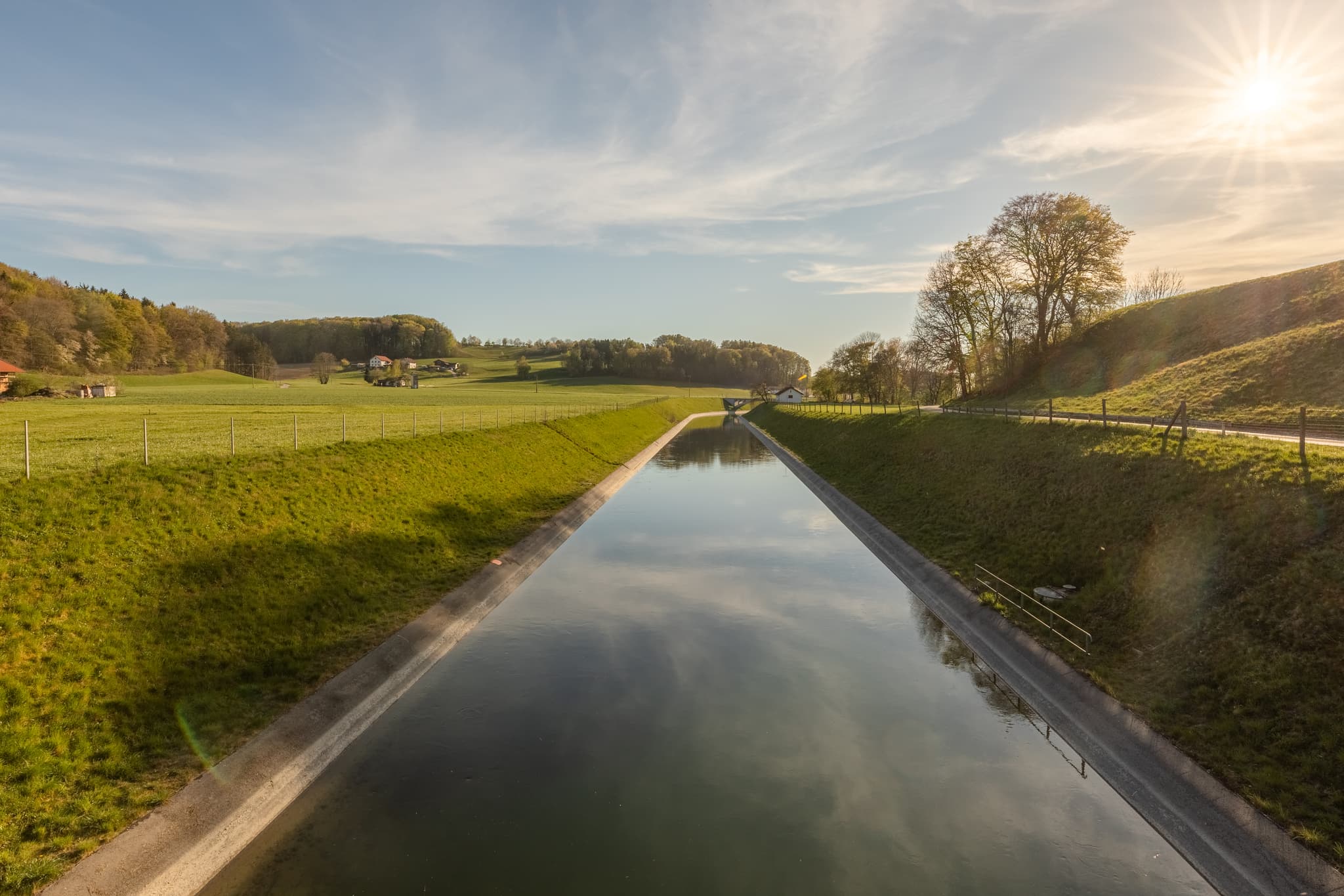 Alzkanal bei Eschlberg, Altötting, Oberbayern - Alzkanals in Auberg, Hintermehring, Mehring, Landkreis Altötting, Oberbayern, Inn-Salzach, Deutschland, präsentiert grüne Wiesen und Hügel entlang des Kanals.