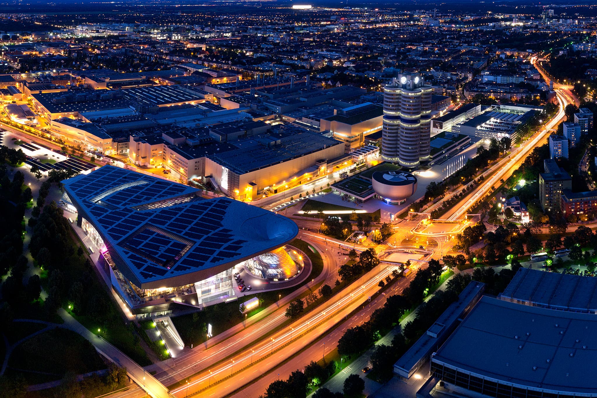Aussicht Olympiaturm, BMW Welt, BMW Turm und Museum, München - Nächtliche Ansicht vom Fernsehturm in München, Oberbayern, Deutschland. Beleuchtete Kulisse der Stadt mit BMW-Welt und Mittlerer Ring.