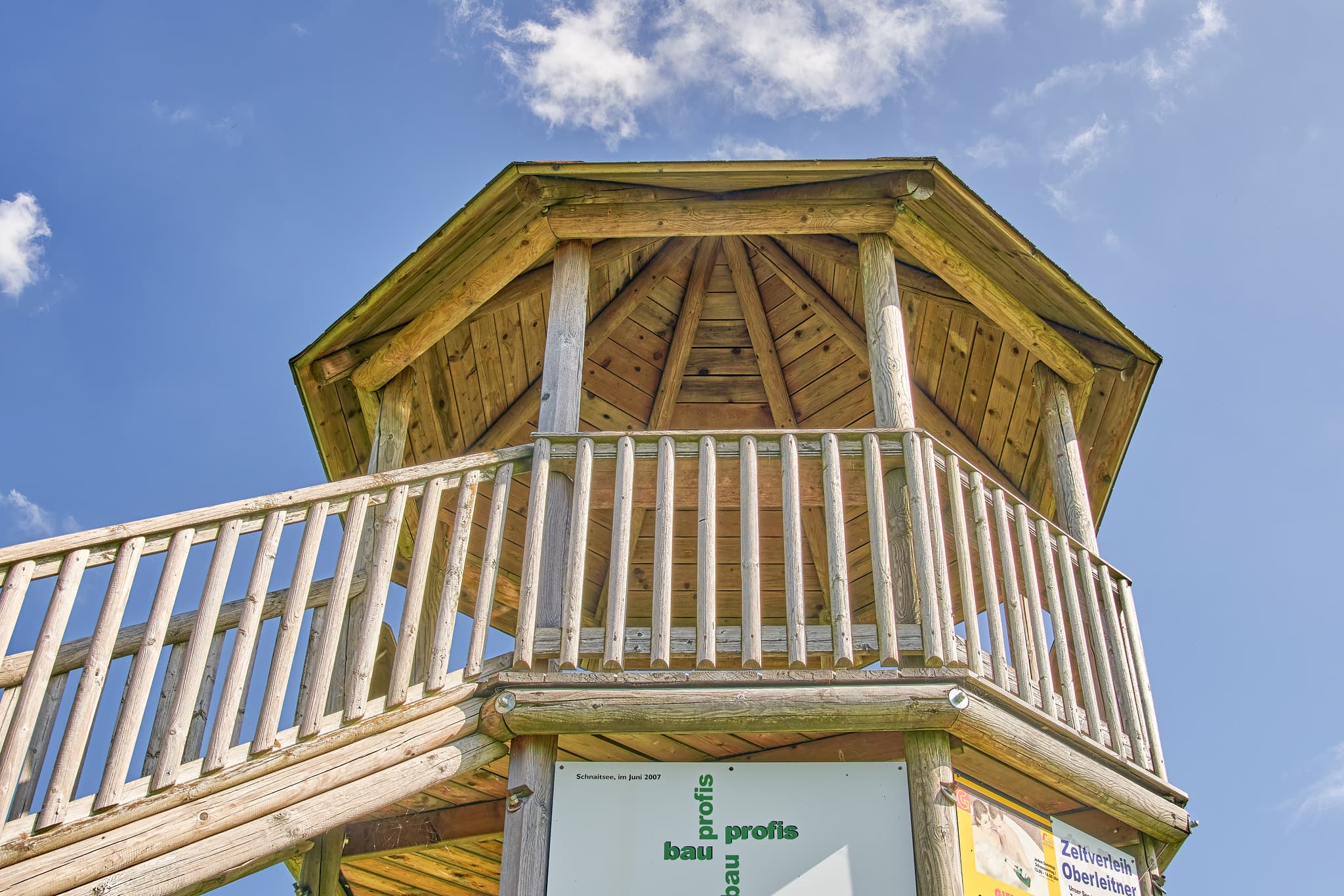 Aussichtsturm Schnaitsee, Traunstein, Oberbayern - Holz-Aussichtsturm in Schnaitsee, Landkreis Traunstein, Oberbayern, Chiemgau, Deutschland. Ansicht des hölzernen Turms bei blauem Himmel und leichter Bewölkung.