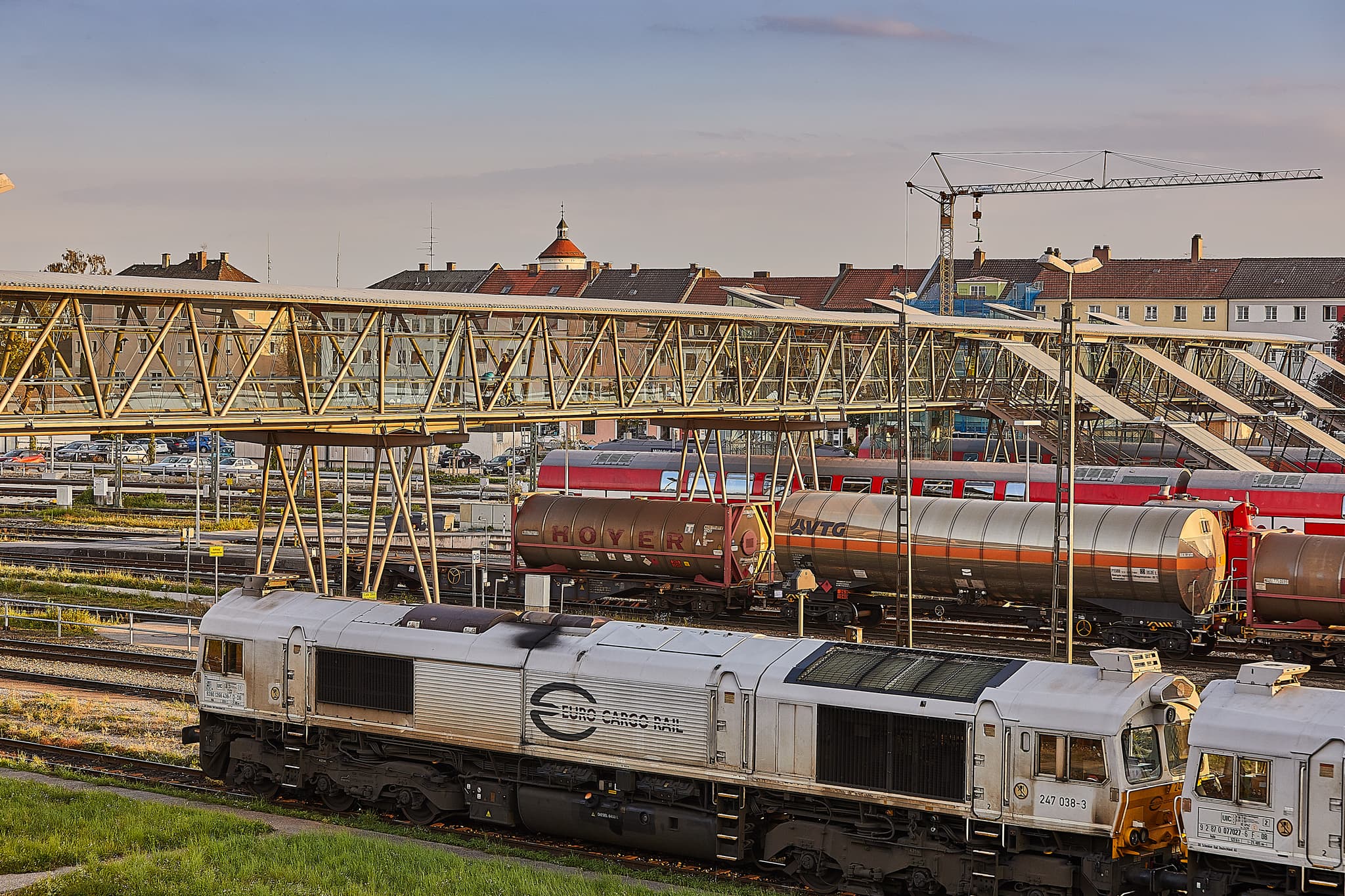 Bahnhof Mühldorf am Inn in Oberbayern mit Gleisbrücke - Detailaufnahme vom Bahnhof Mühldorf am Inn in Oberbayern. Dieser Verkehrsknotenpunkt zeigt abgestellte Güterzüge und die moderne Fußgängerbrücke.
