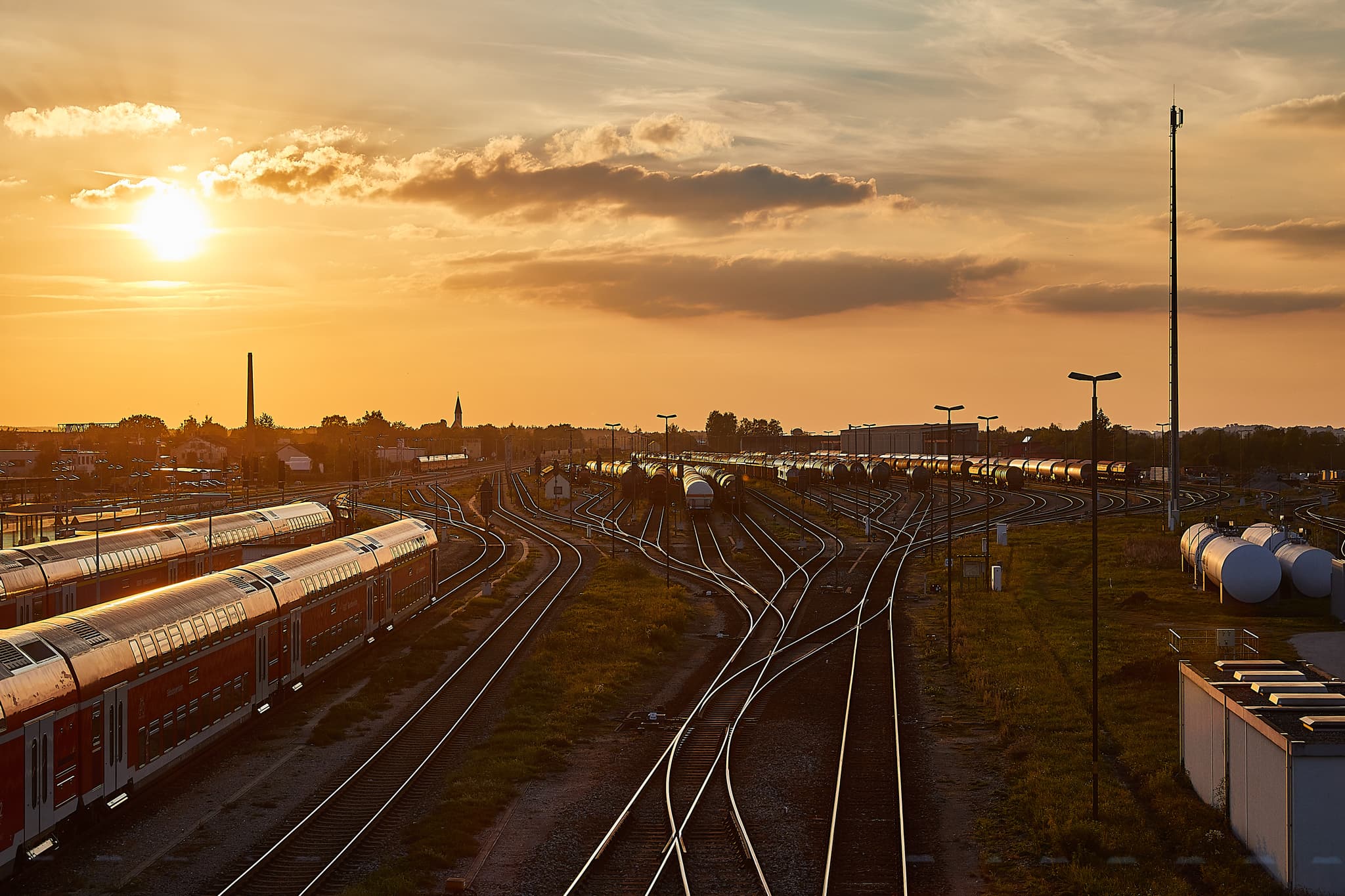 Bahnhof Mühldorf am Inn, MÜ, Oberbayern, Inn-Salzach Region - Bahnhof Mühldorf am Inn, Oberbayern. Gleisanlagen, Züge, Tanks im Sonnenuntergang. Industrielandschaft der Inn-Salzach Region im Landkreis Mühldorf am Inn.