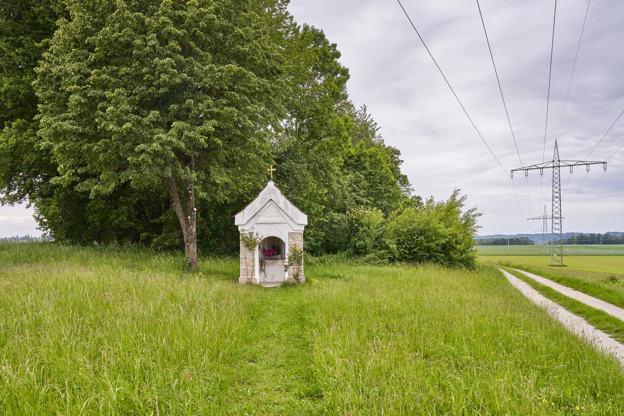 Bildstock Kapelle, Höresham, Altötting, Oberbayern - Ansicht einer Kapelle mit Marienstatue hinter Gitter und Blumen in Höresham, Burgkirchen. Im Landkreis Altötting, Oberbayern, Region Inn-Salzach, Deutschland.