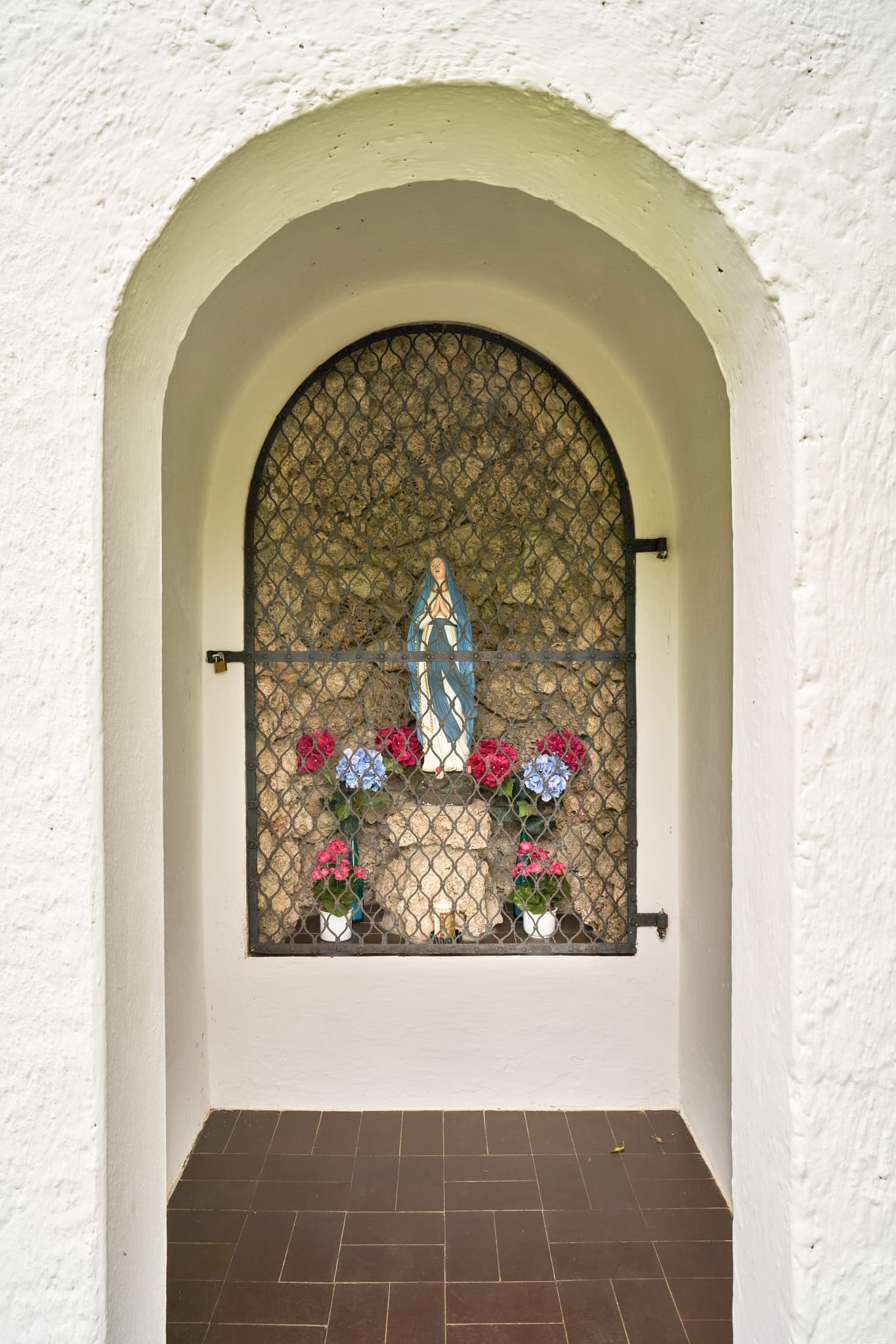 Bildstock Kapelle, Höresham, Altötting, Oberbayern - Ansicht einer Kapelle mit Marienstatue hinter Gitter und Blumen in Höresham, Burgkirchen. Im Landkreis Altötting, Oberbayern, Region Inn-Salzach, Deutschland.