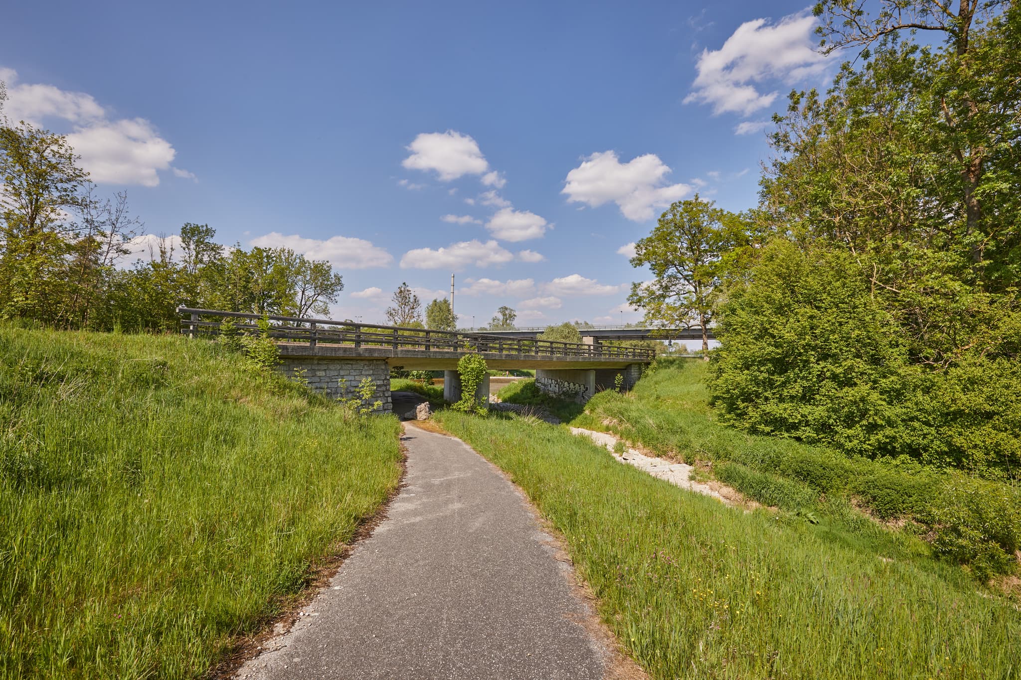 Burgkirchen-Hirten Alz Radweg, Burgkirchen, Oberbayern - Radweg unter Brücke, umgeben von Wiesen und Bäumen. Ansicht bei Burgkirchen, Landkreis Altötting, Oberbayern. Landschaft der Region Inn-Salzach