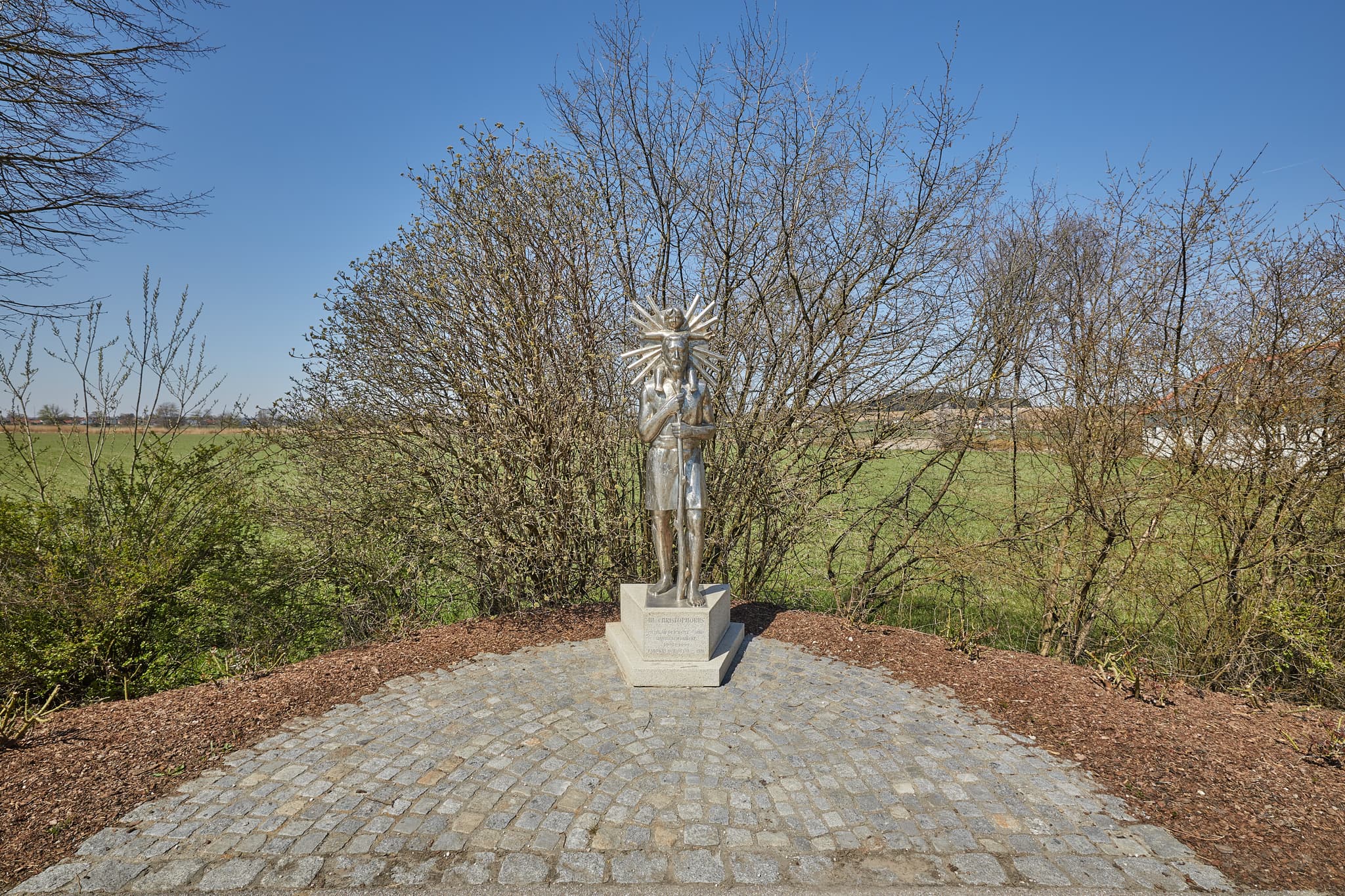 Christopherus, Unterdietfurt, Rottal-Inn, Niederbayern - Statue des Heiligen Christopherus in Unterdietfurt, Rottal-Inn, Niederbayern. Die Skulptur befindet sich im Holzland, Deutschland, unter blauem Himmel.