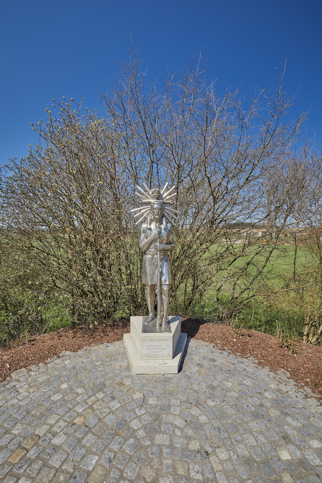 Christopherus, Unterdietfurt, Rottal-Inn, Niederbayern - Statue des Heiligen Christopherus in Unterdietfurt, Rottal-Inn, Niederbayern. Die Skulptur befindet sich im Holzland, Deutschland, unter blauem Himmel.