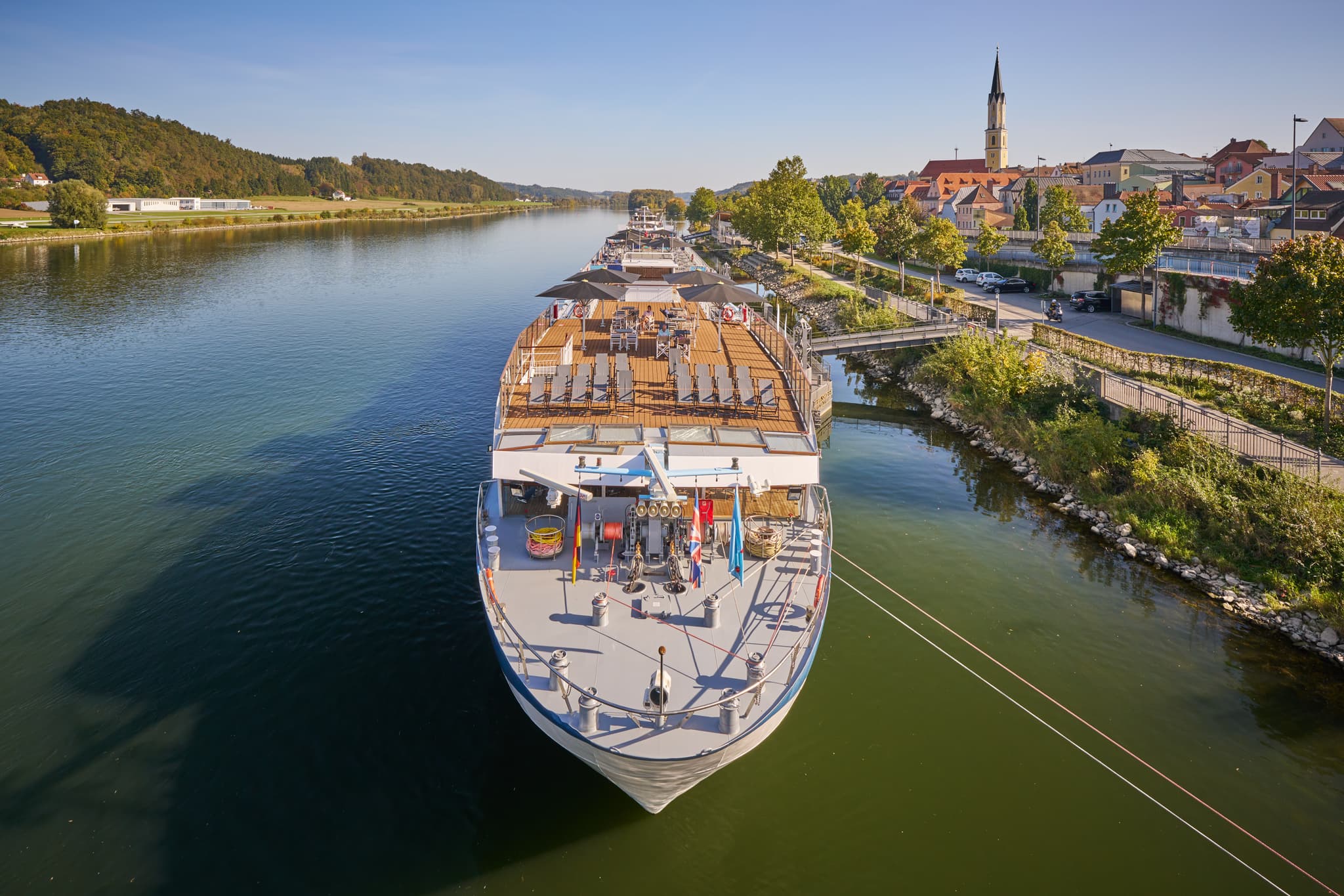 Donau Hafen in Vilshofen, Passau, Niederbayern, bei Tag - Flusskreuzfahrtschiff liegt am Donau Hafen in Vilshofen, Landkreis Passau, Niederbayern. Stadtkulisse am Flussufer im Donau-Wald, Deutschland.
