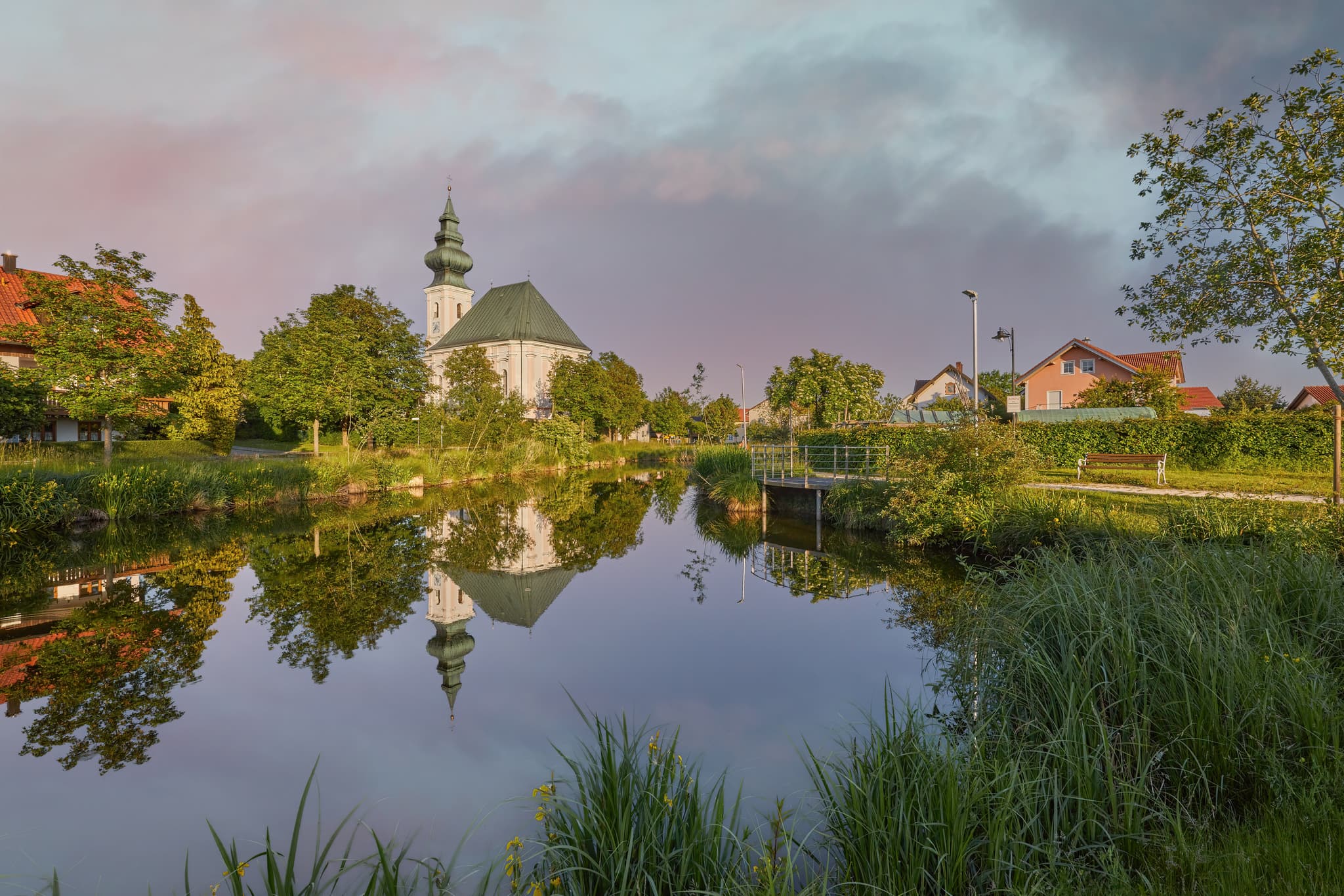 Dorfweiher mit Kirche, Kirchweidach, Oberbayern, Inn-Salzach - Idyllische Dorfweiher Kirche in Kirchweidach, Oberbayern, im Inn-Salzach Gebiet, Deutschland. Ein malerisches Motiv mit Spiegelung im Wasser.