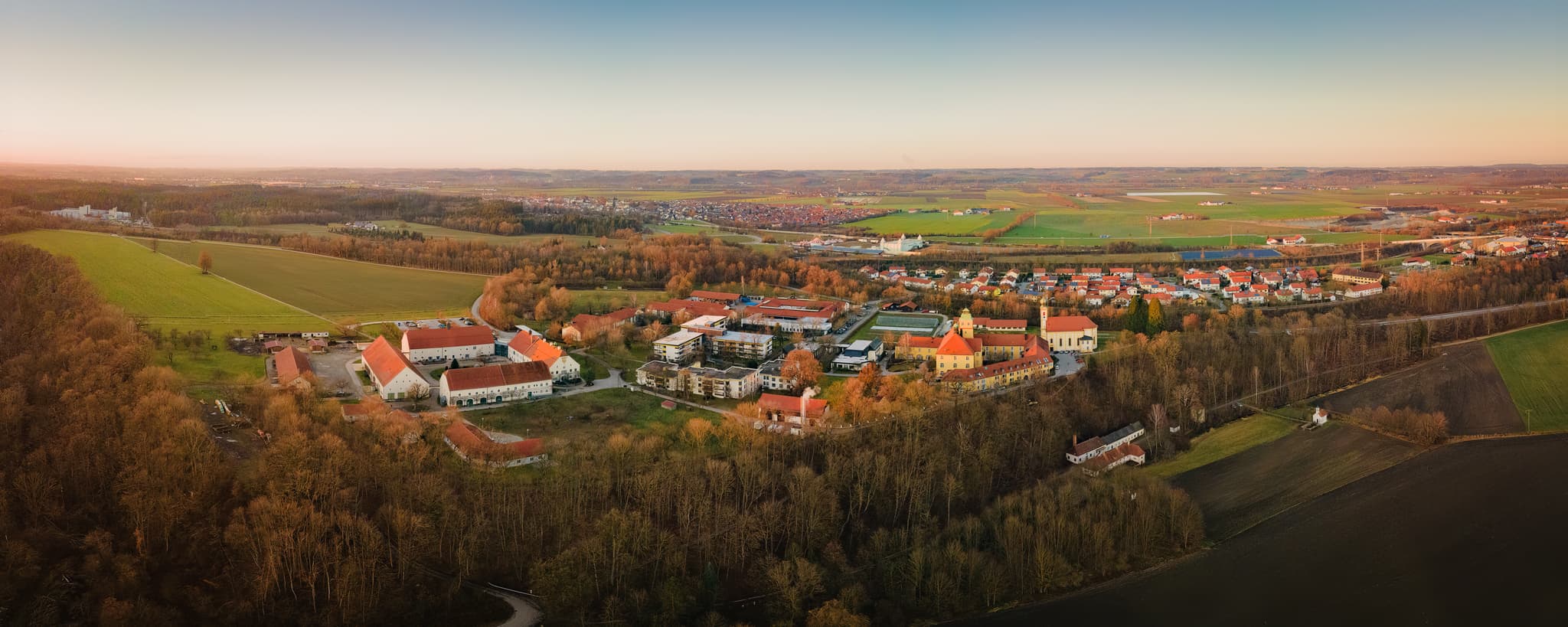 Ecksberg, Mühldorf am Inn, Oberbayern, Inn-Salzach - Luftaufnahme des Ortsteils Ecksberg, Mühldorf am Inn, Oberbayern. Zeigt Gebäudekomplexe, weite Wälder, Felder der Inn-Salzach Region in Abendstimmung.