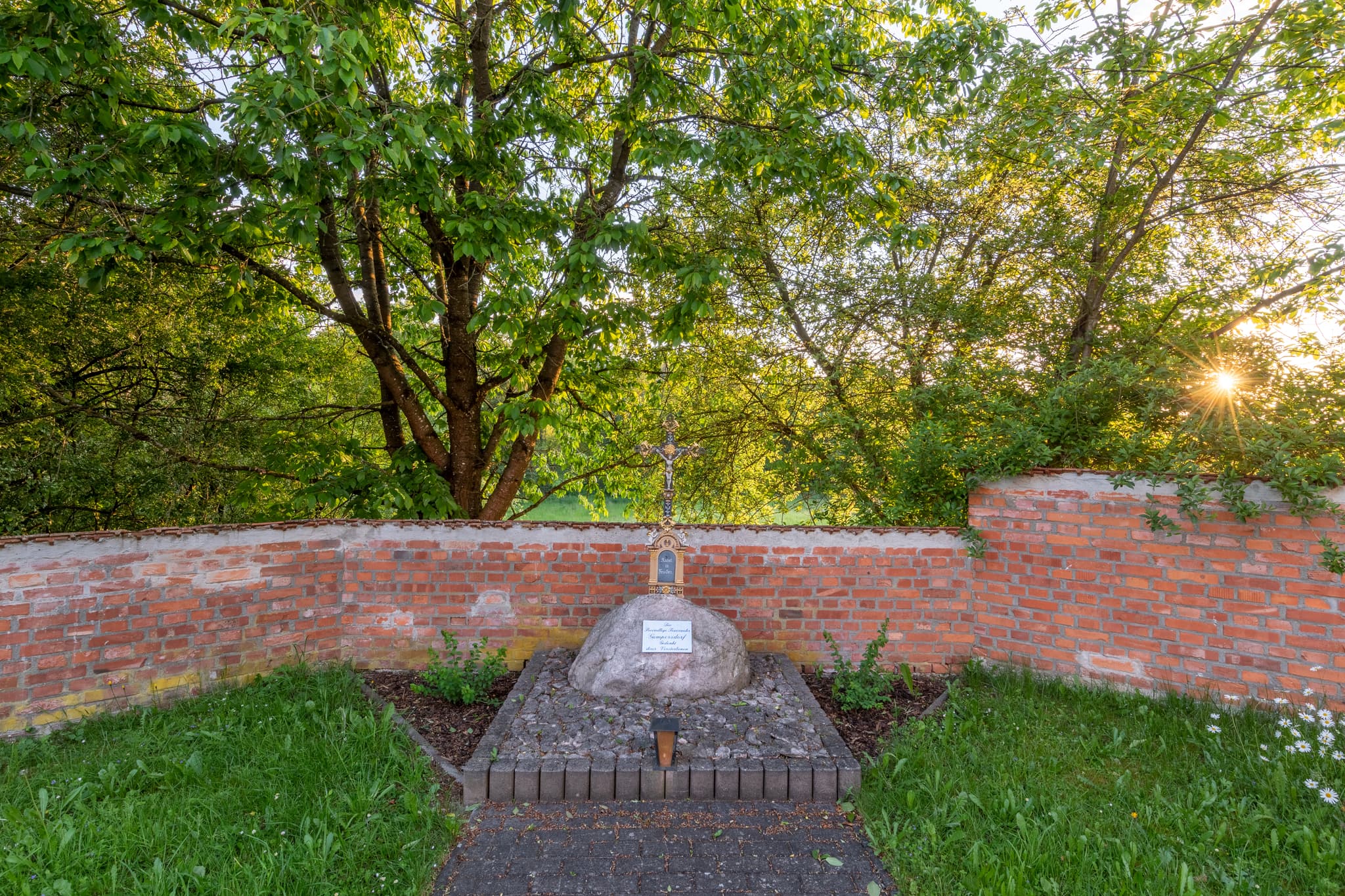 Filialkirche St. Rupert, Gedenkstein, Zeilarn, Gumpersdorf - Filialkirche St. Rupert in Gumpersdorf, Zeilarn, Landkreis Rottal-Inn, Niederbayern, Deutschland. Sakralbau im Holzland, Mauer und Bäume, bei Abendsonne.