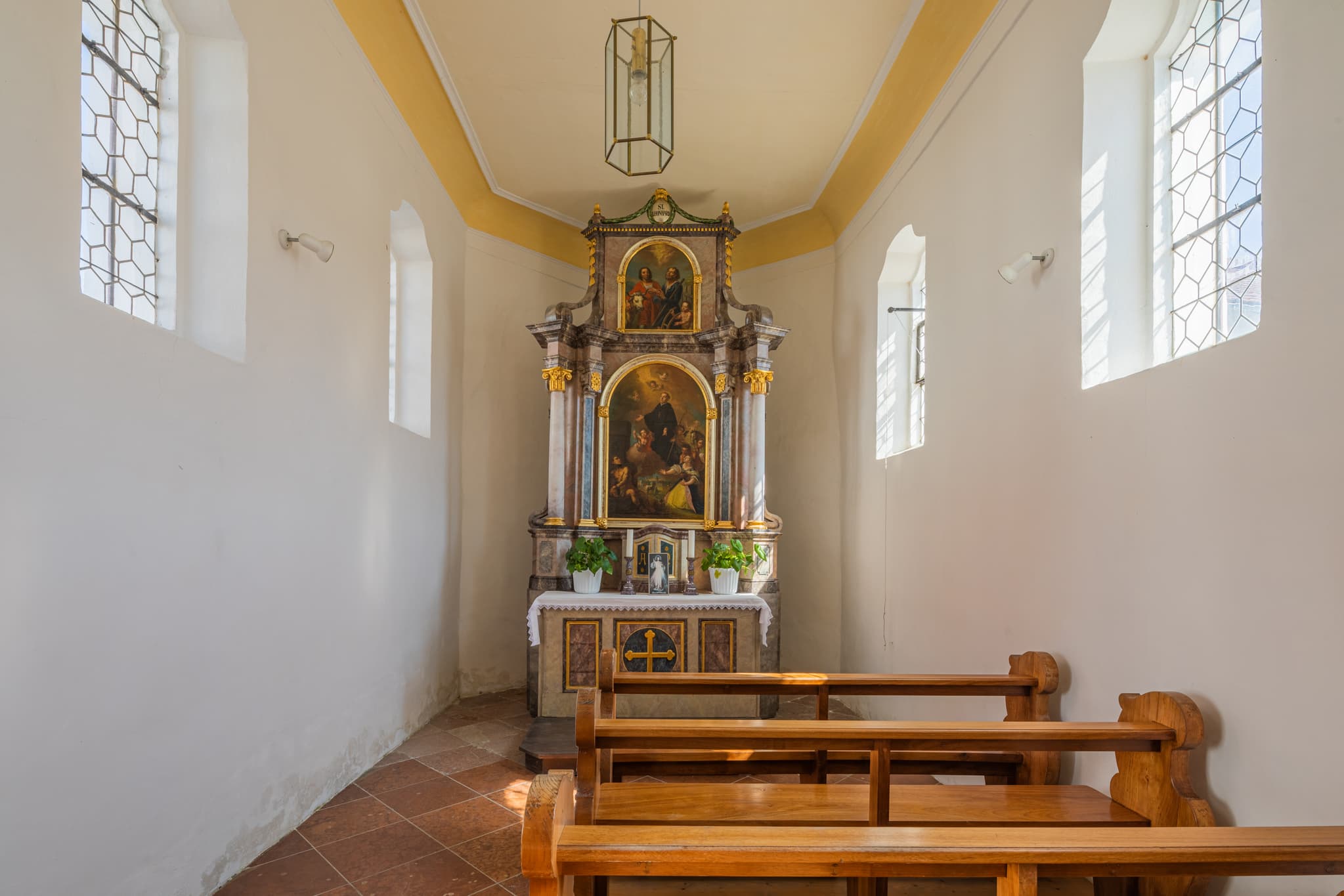 Friedhofskapelle, Unterdietfurt, Rottal-Inn, Niederbayern - Innenansicht der Friedhofskapelle in Unterdietfurt, Landkreis Rottal-Inn, Niederbayern. Das Motiv zeigt den Altarbereich mit Holzbänken und Fenstern.