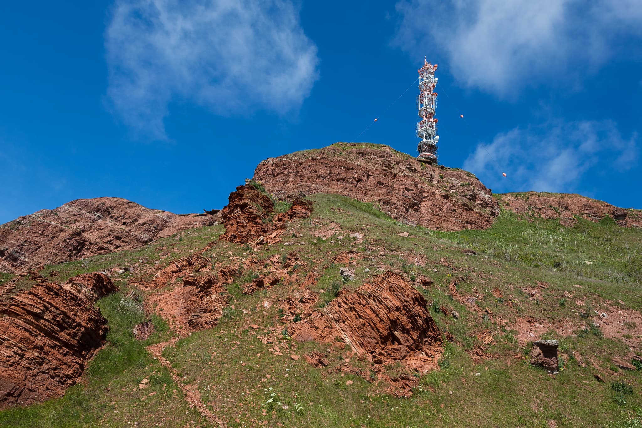 Funkturm, Helgoland Unterland, Pinneberg, Schleswig-Holstein - Funkturm auf rotem Felsenhügel mit grüner Vegetation. Aufgenommen in Helgoland Unterland, Helgoland, Kreis Pinneberg, Schleswig-Holstein, Nordsee, Deutschland.
