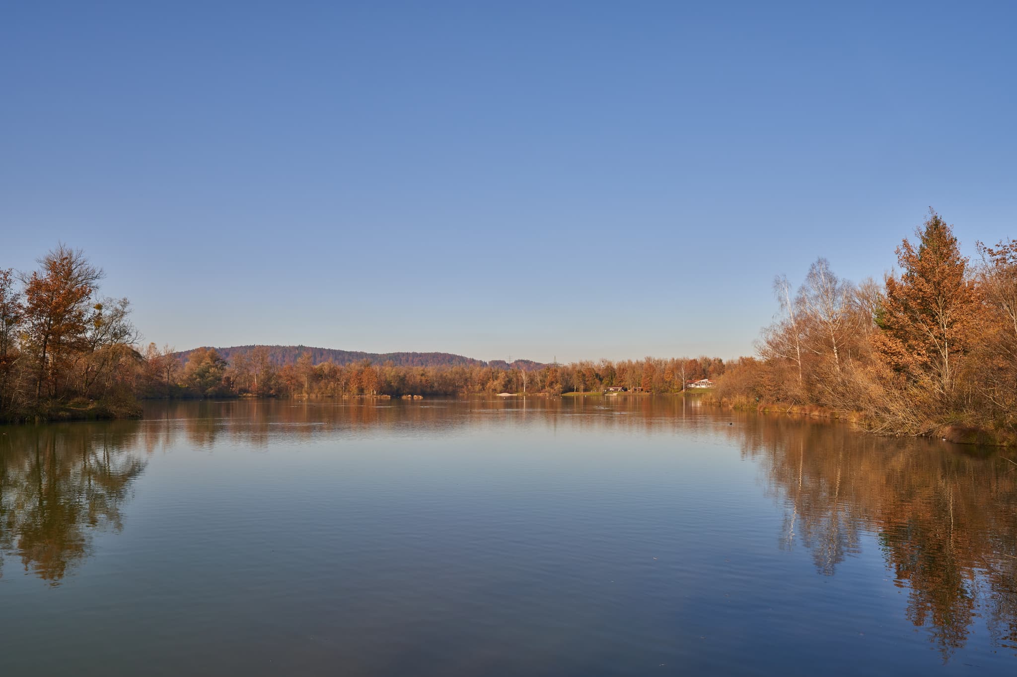 Herbst am Waldsee Lago, Kirchdorf am Inn, Niederbayern - Idyllischer Waldsee Lago in Kirchdorf am Inn, Landkreis Rottal-Inn, Niederbayern. Herbstliche Bäume spiegeln sich auf dem Wasser.