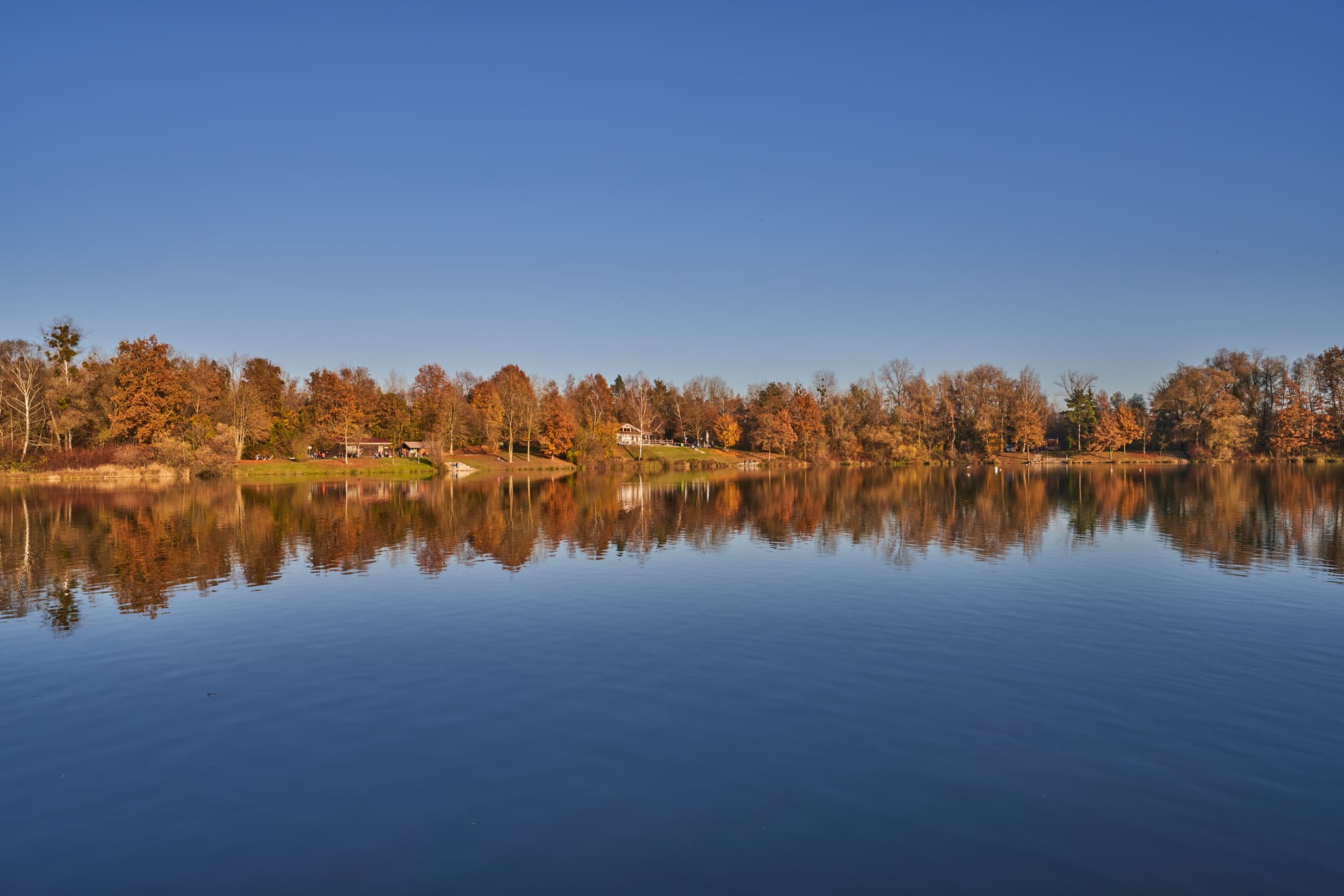 Herbst am Waldsee Lago, PAN, Niederbayern, Bäderdreieck - Herbstliche Naturaufnahme am Waldsee Lago bei Kirchdorf am Inn, Rottal-Inn, Niederbayern. Bunte Bäume spiegeln sich im ruhigen Wasser unter blauem Himmel.