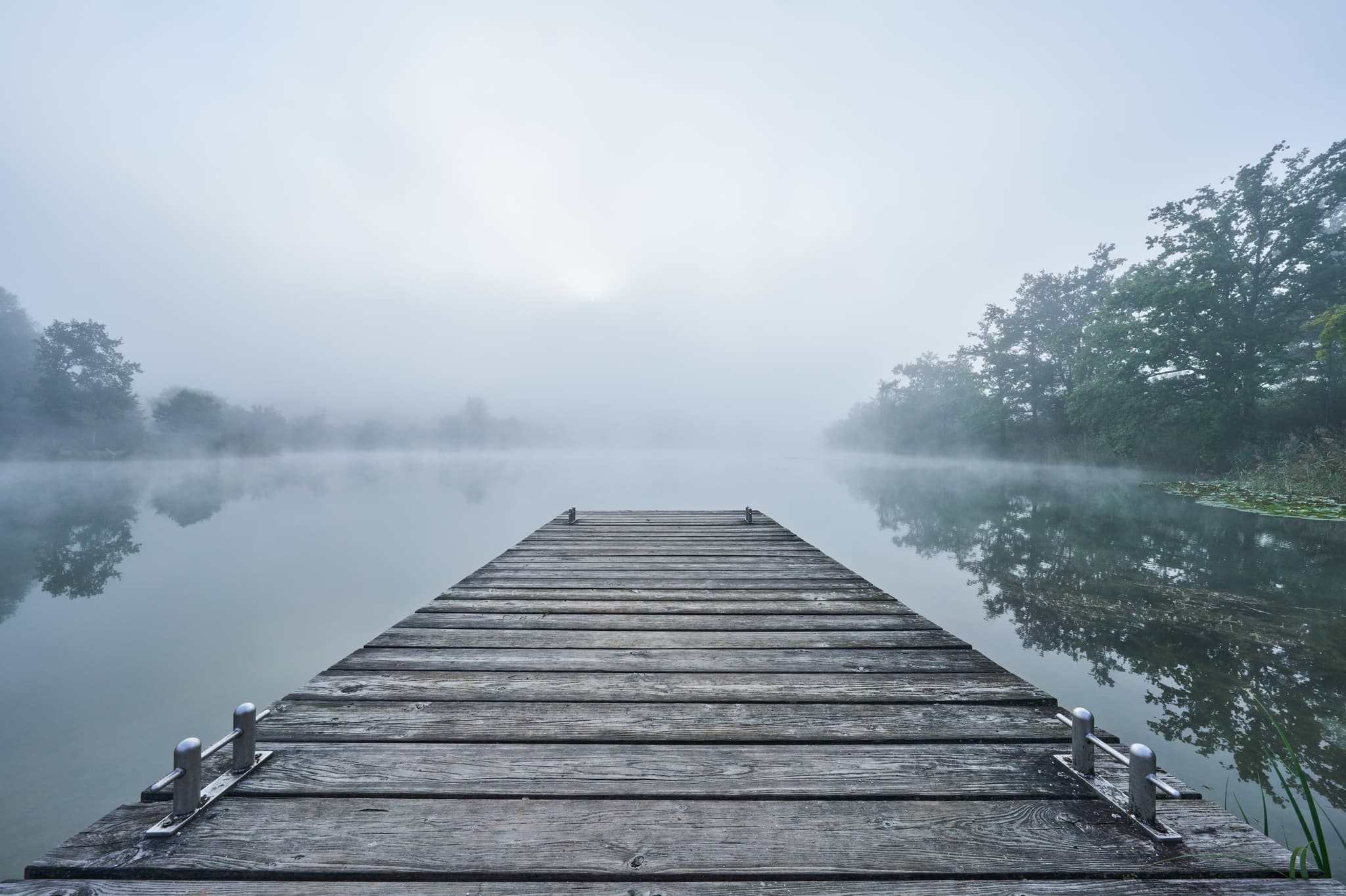 Herbst Morgennebel am Badesee, Altötting, Oberbayern - Holzsteg auf dem nebligen Badesee in Marktl, Landkreis Altötting, Oberbayern. Herbstliche Morgenstimmung in der Region Inn-Salzach, Deutschland.