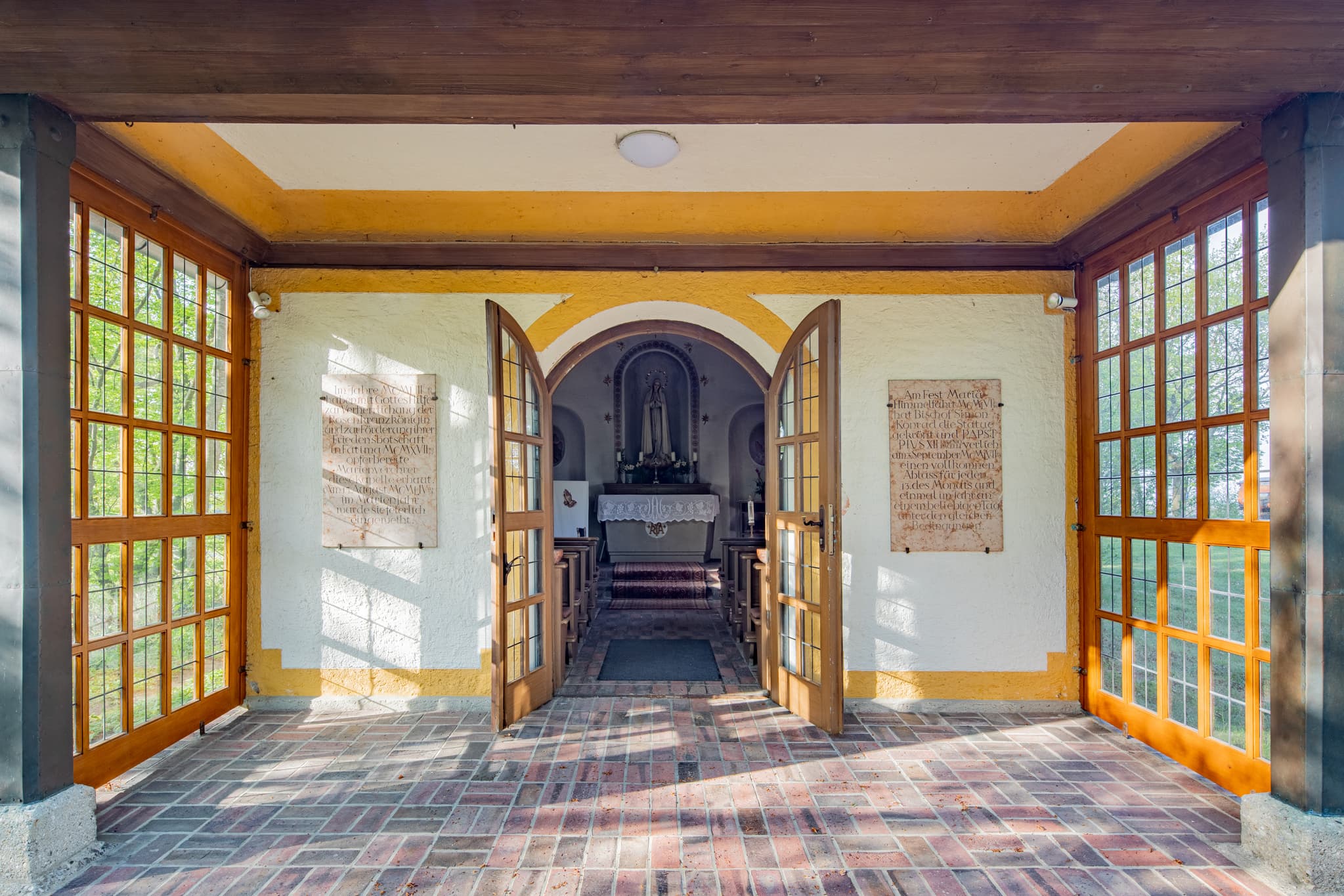 Hirten Kapelle Margarethenberg, Altötting, Oberbayern - Hirten Kapell,e Margarethenberg in Burgkirchen, Altötting. Kapelle Oberbayern, Inn-Salzach, Deutschland. Überdachter Eingang mit Holztüren, Ziegelfliesenboden.