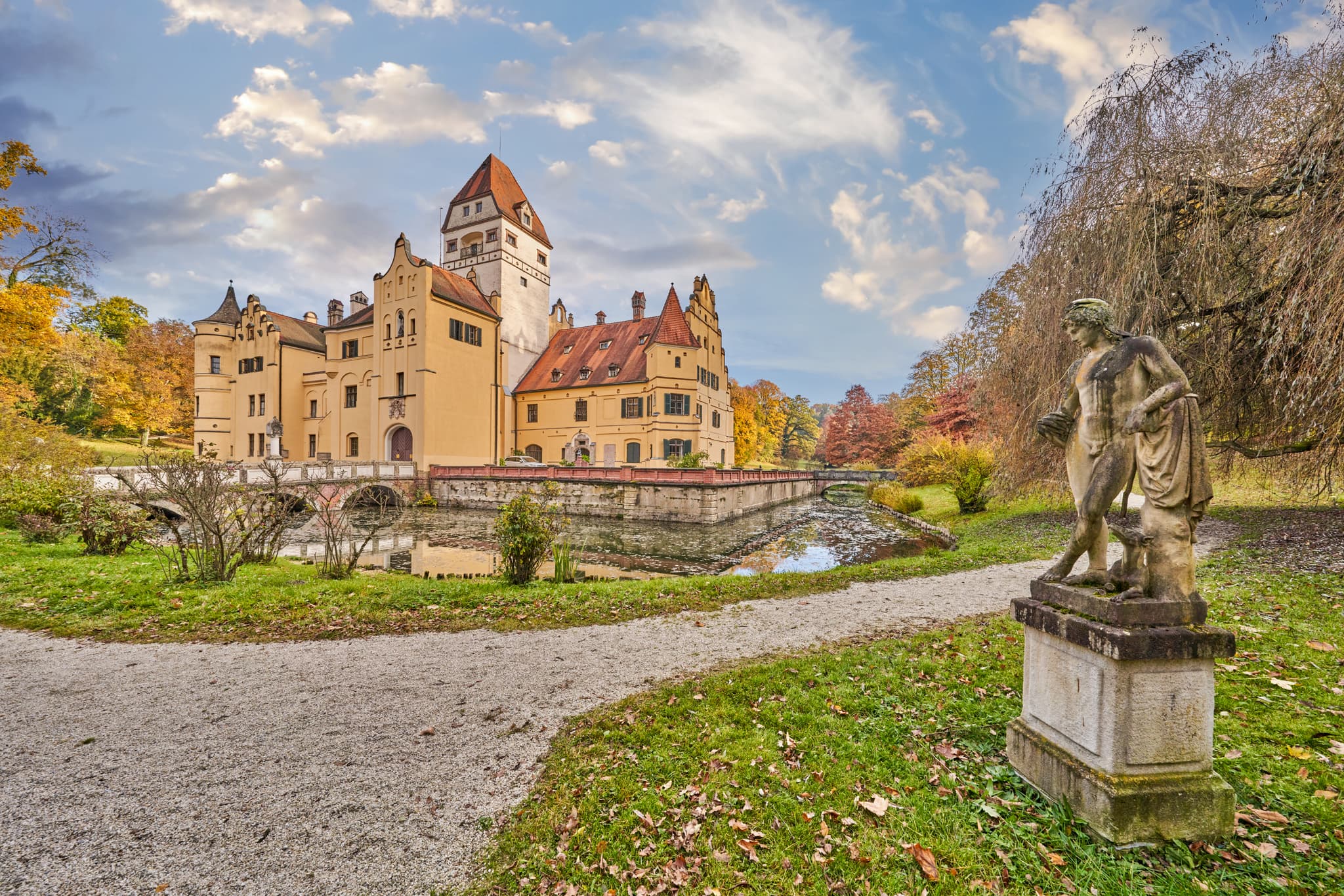 Hörnliweg, Schlosspark Schönau, Rottal-Inn, Niederbayern - Historisches Schloss Schönau im Schlosspark. Wasserschloss mit Brücke in Rottal-Inn, Niederbayern. Herbstlandschaft im Holzland, Deutschland, Statue und Wege.