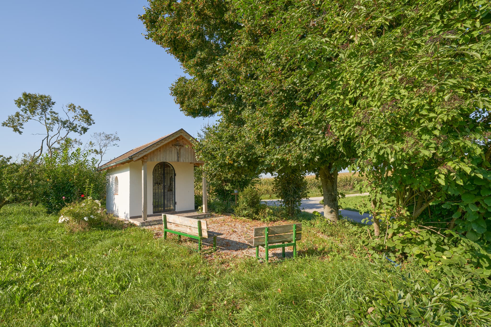 Kapelle am St.-Rupert-Pilgerweg in Reit, Kastl, Altötting - Kapelle in Reit, ländliche Abzweigung mit Feldwegen, umgeben von grünen Wiesen und Äckern in Kastl, Landkreis Altötting, Oberbayern.