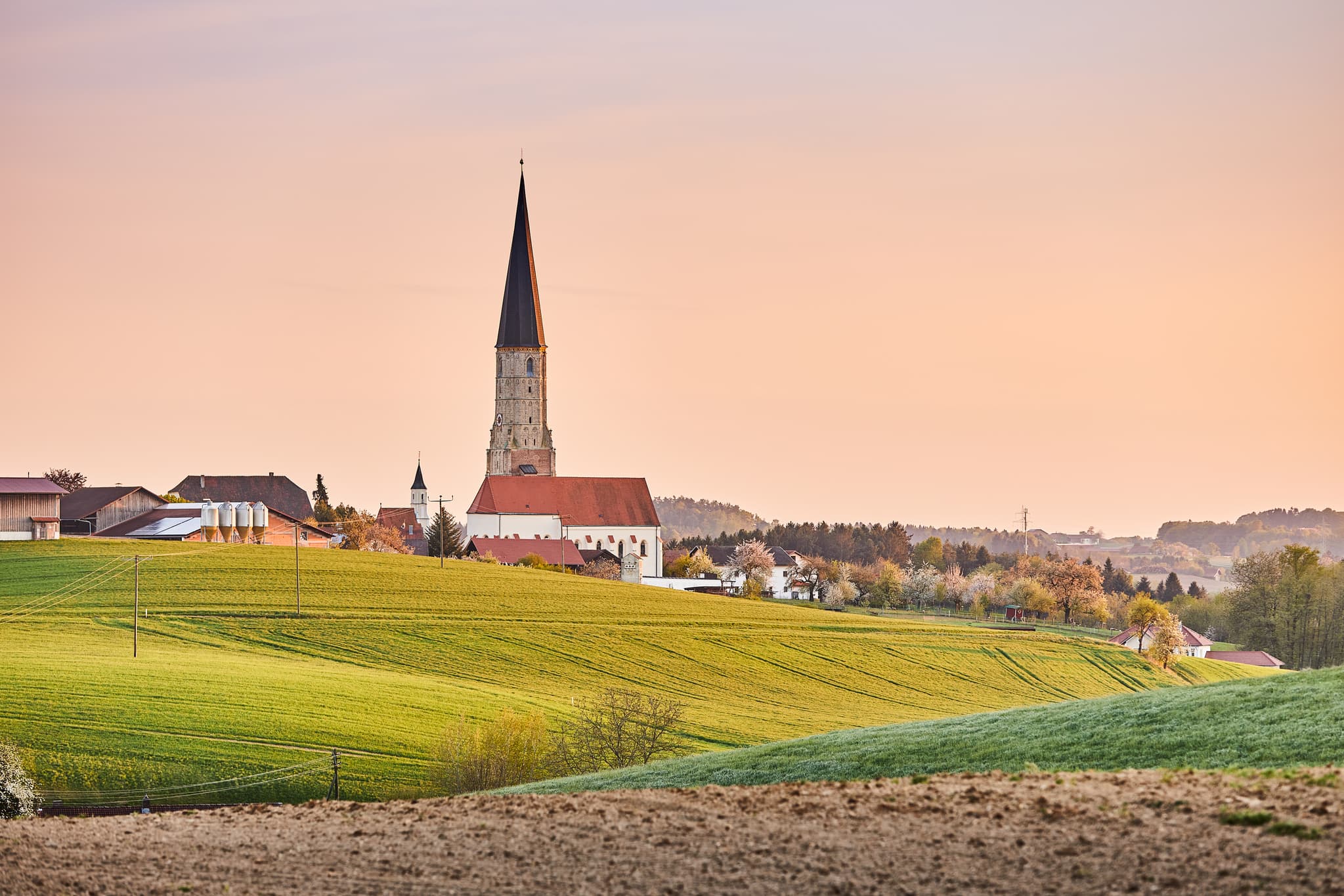 Kirche aus Schmiding, Schildthurn, Niederbayern, Holzland - Kirche in Schildthurn, Ortsteil von Zeilarn, Landkreis Rottal-Inn, Niederbayern. Ländliche Landschaft des Holzlandes mit Hügeln und Feldern bei Dämmerung.