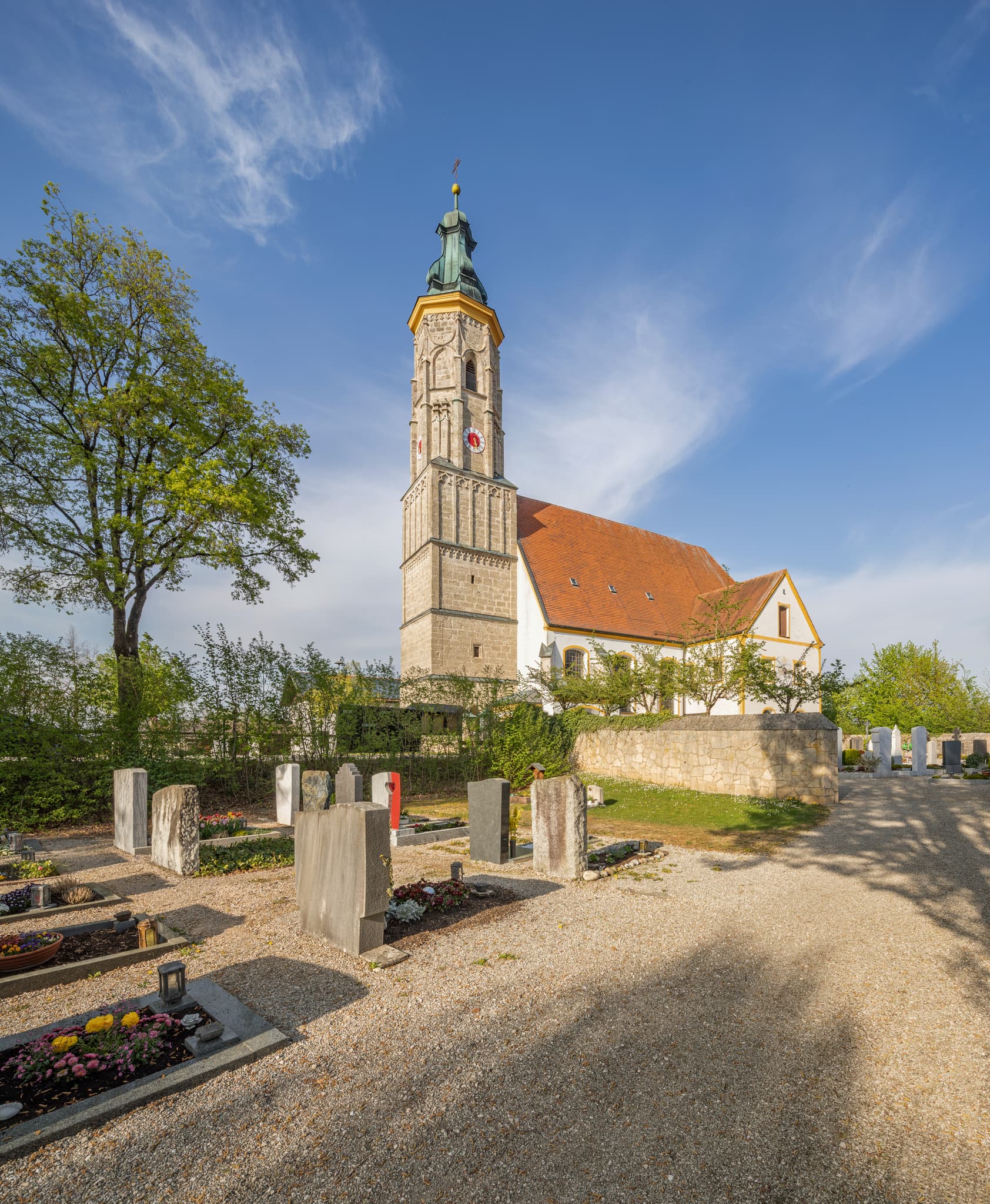 Kirche Margarethenberg, Hirten AÖ, Oberbayern, Inn-Salzach - Margarethenberg Kirche in Hirten, Burgkirchen, Altötting, Oberbayern, Inn-Salzach, Deutschland. Außenansicht mit Turm und Friedhof bei blauem Himmel.