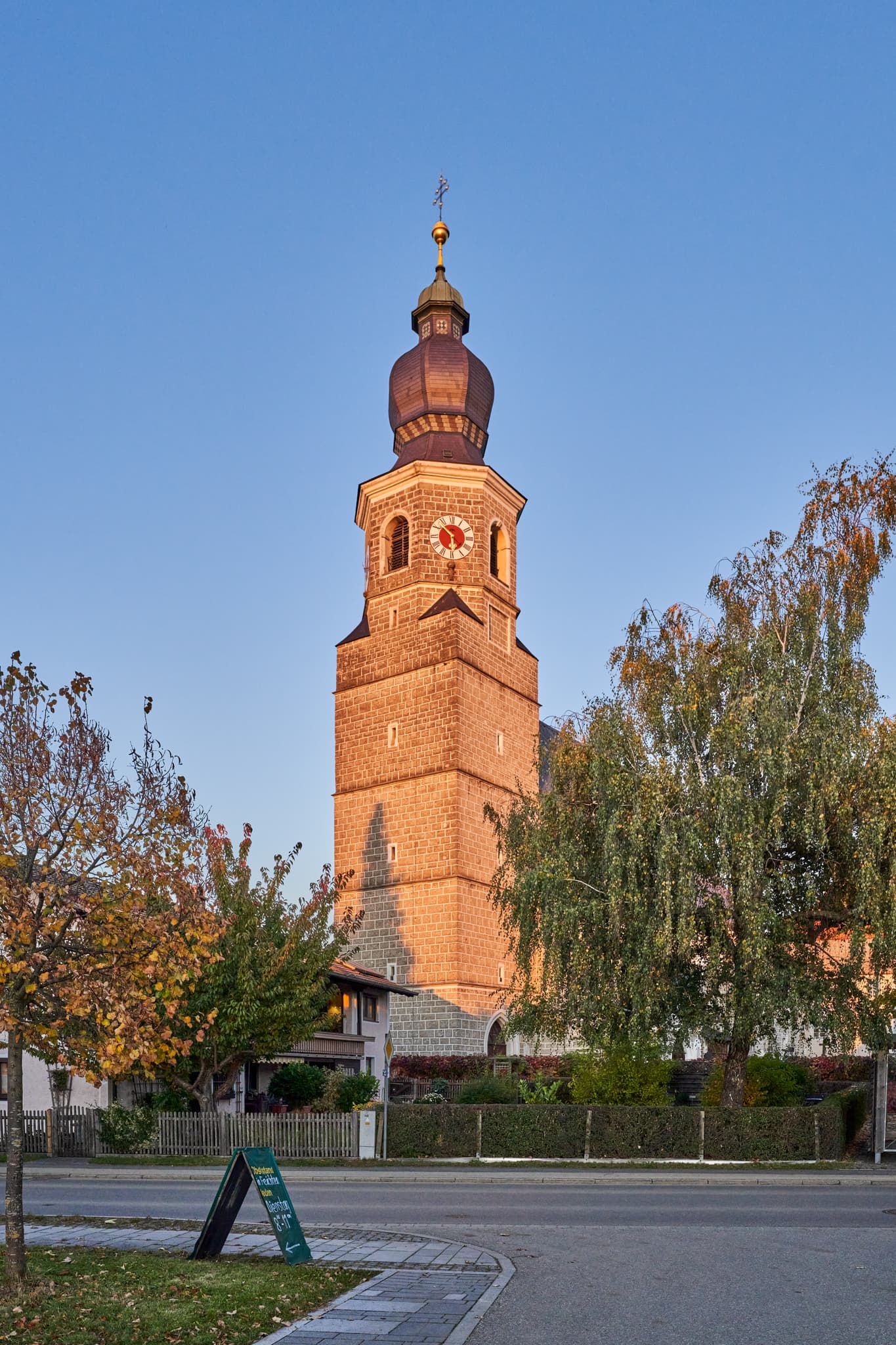 Kirche Mariä Himmelfahrt, Feichten, Oberbayern, Inn-Salzach - Kirche Mariä Himmelfahrt, Feichten, Altötting, Oberbayern, Deutschland. Ihr Kirchturm prägt Ortsbild der Inn-Salzach Region. Umgeben von Bäumen und Gebäuden.