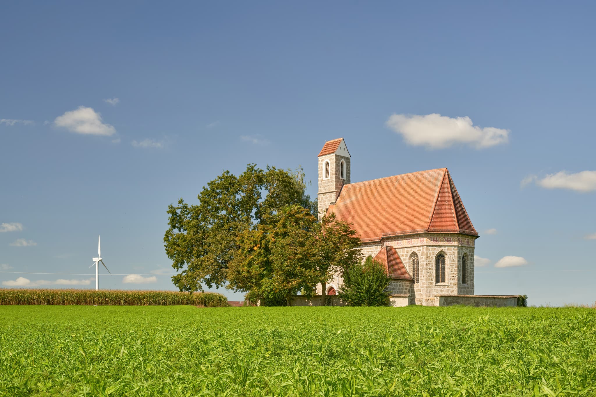 Kirche St. Alban, Peterskirchen, Tacherting, Traunstein - Kirche St. Alban, Peterskirchen, Tacherting, Landkreis Traunstein, Oberbayern. Motiv der Kirche umgeben von Feldern im Chiemgau, Deutschland.