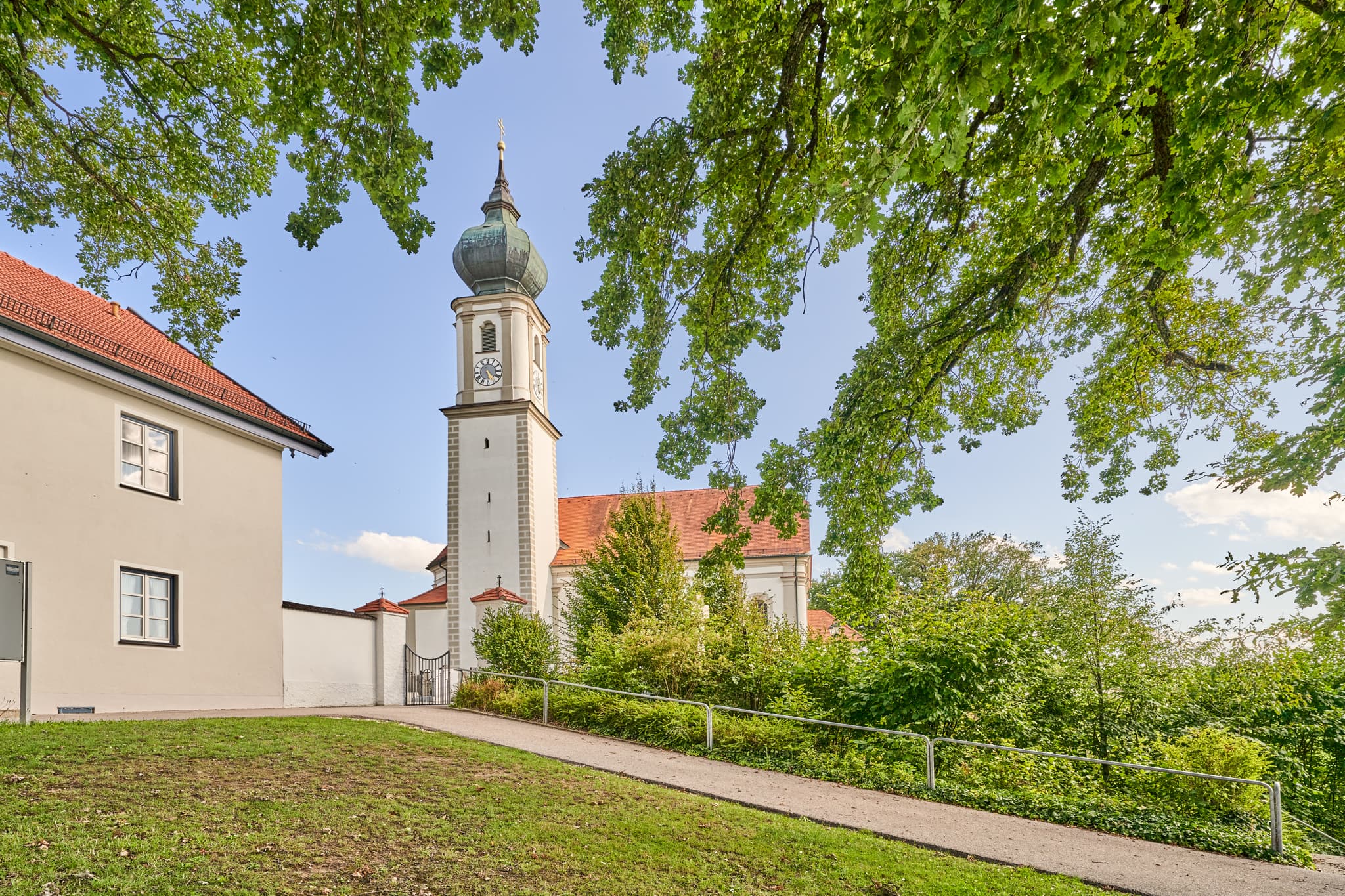 Kirche St. Martin Niedertaufkirchen, Mühldorf, Oberbayern - Die Kirche St. Martin in Niedertaufkirchen, Landkreis Mühldorf am Inn, Oberbayern. Historisches Gotteshaus mit Zwiebelturm, umgeben von Grün.