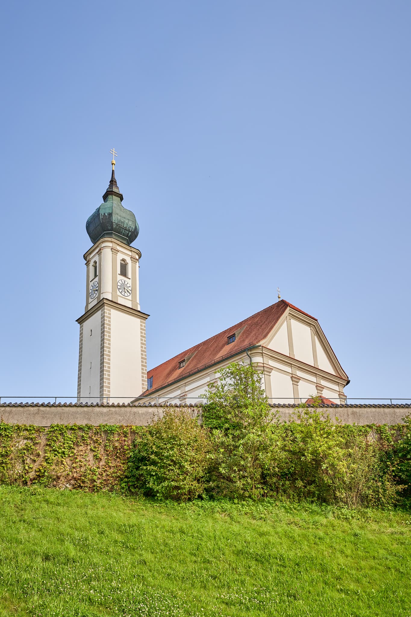 Kirche St. Martin, Niedertaufkirchen, Mühldorf, Oberbayern - Kirche St. Martin, Niedertaufkirchen, Mühldorf am Inn, Oberbayern, Inn-Salzach. Historisches Gotteshaus mit Zwiebelturm und Mauer. Grüne Wiese, blauer Himmel.