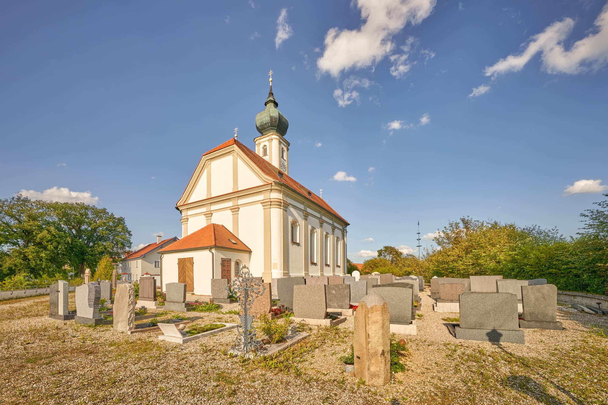 Kirche St. Martin, Niedertaufkirchen, Mühldorf, Oberbayern - Kirche St. Martin, Niedertaufkirchen, Mühldorf am Inn, Oberbayern. Gotteshaus mit Friedhof unter blauem Himmel.