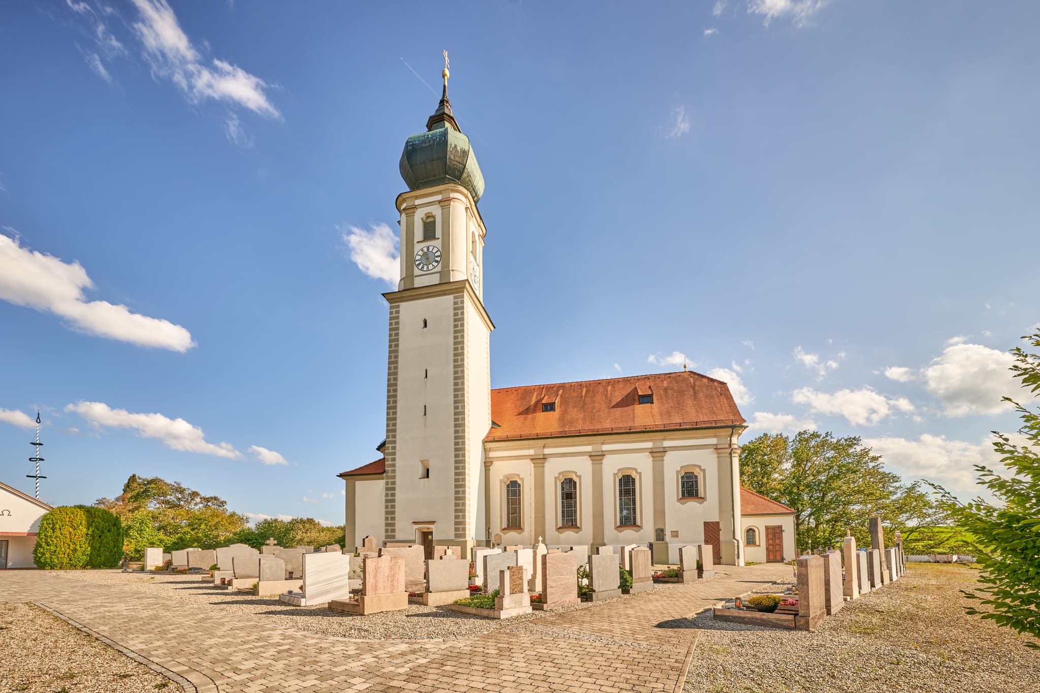 Kirche St. Martin, Niedertaufkirchen, Mühldorf, Oberbayern - Kirche St. Martin in Niedertaufkirchen, Landkreis Mühldorf am Inn, Oberbayern. Das Gotteshaus mit Friedhof unter blauem Himmel im Inn-Salzach, Deutschland.