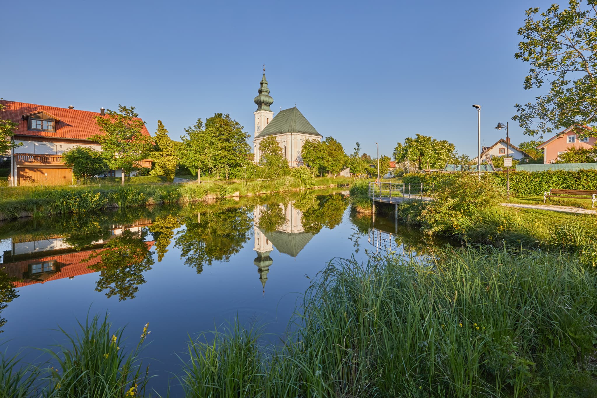 Kirche St. Vitus mit Spiegelung im Dorfweiher, Kirchweidach - Kirchweidach in Oberbayern, Inn-Salzach, Deutschland: Die Dorfweiher Kirche spiegelt sich idyllisch im Wasser. Ein traumhaftes Fotomotiv in der Region.