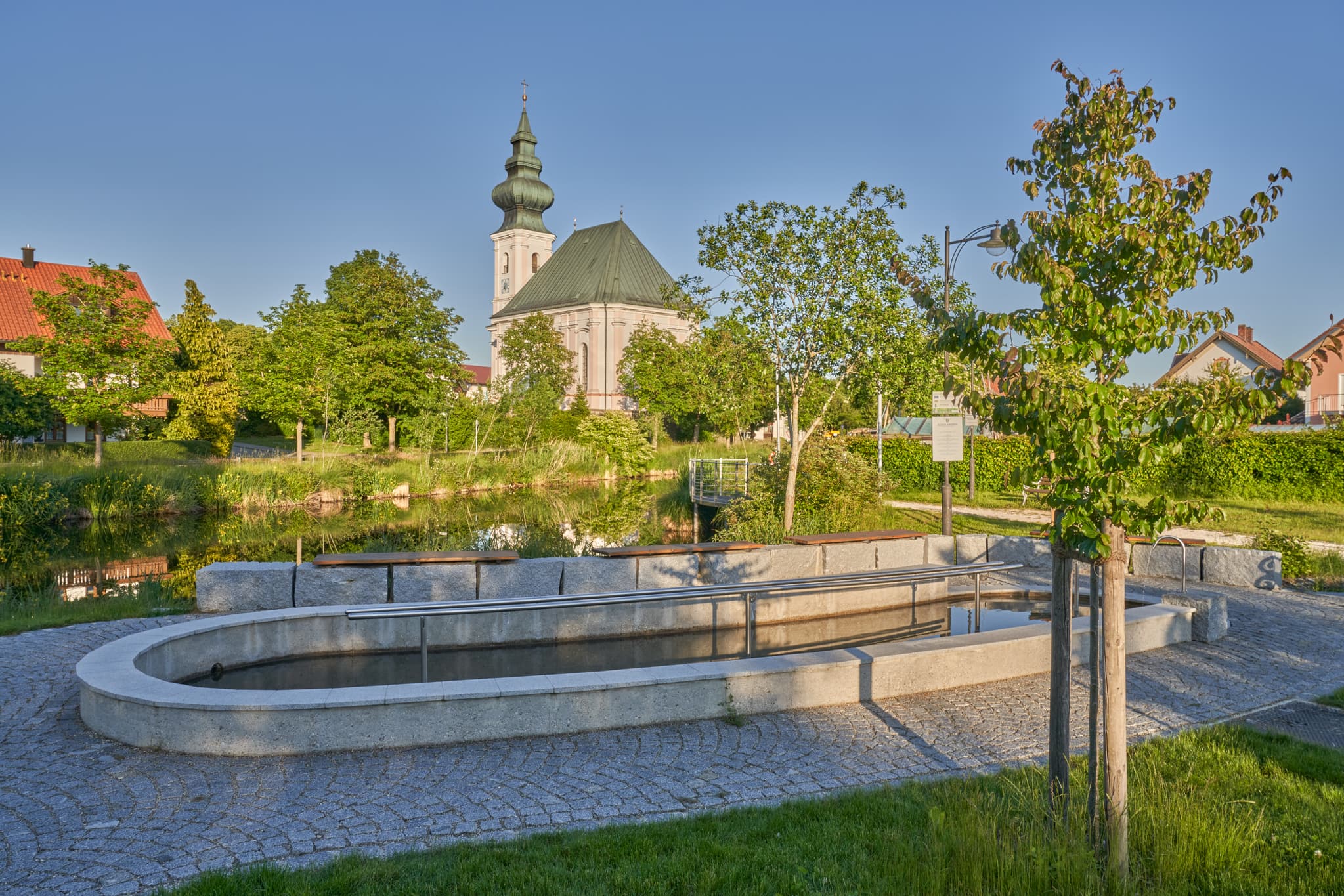 Kneippanlage vor Dorfweiher, Kirche St. Vitus, Kirchweidach - Besuchen Sie die malerische Kneippanlage am Dorfweiher in Kirchweidach, Oberbayern (Inn-Salzach, Bayern, Deutschland). Entspannen Sie an der idyllischen Kirche.