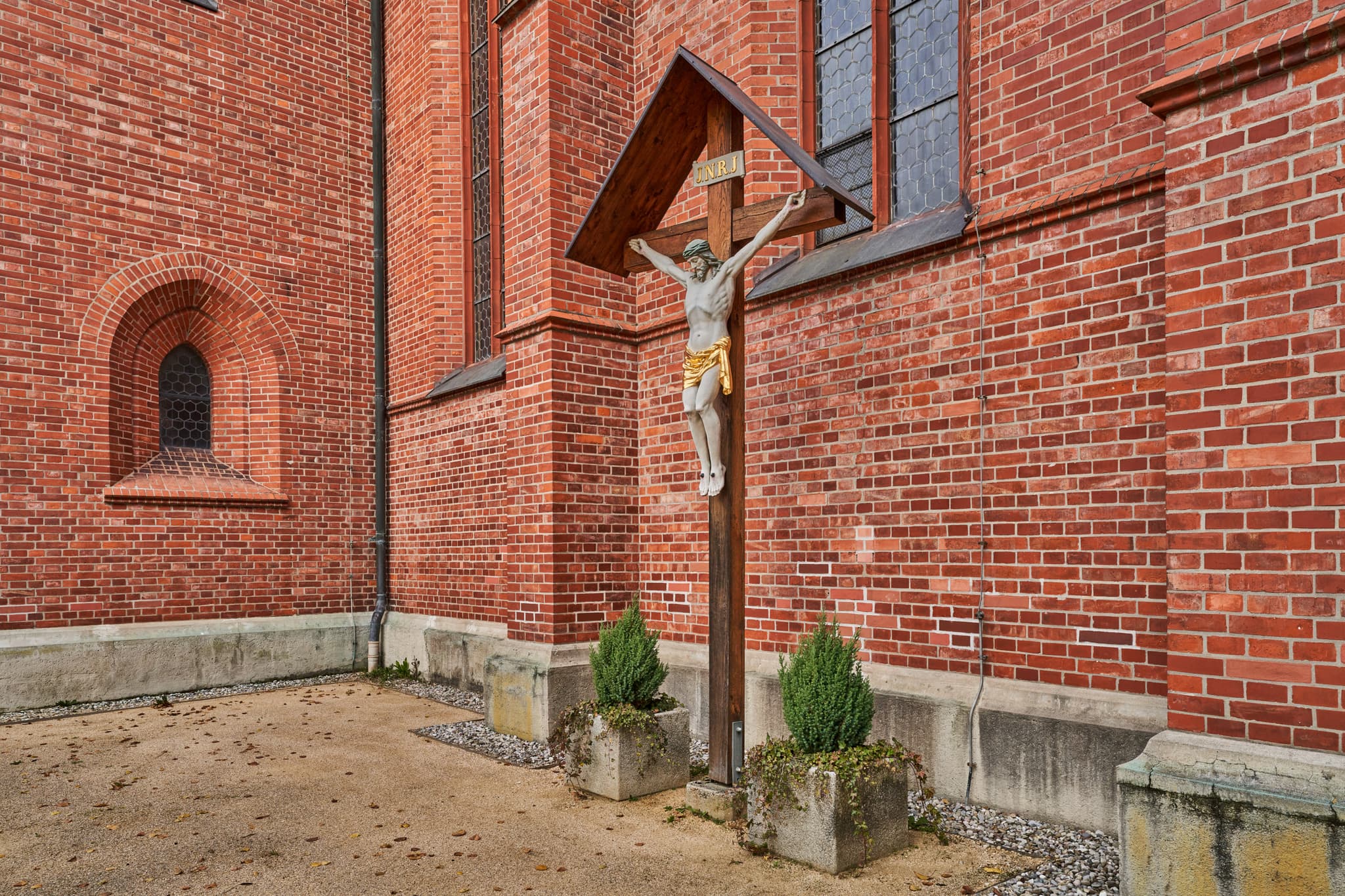 Kreuz an der Kirche St. Stephanus, Schönau, Rottal-Inn - Kruzifix an der Ziegelwand der Kirche St. Stephanus Hörniweg in Schönau, Rottal-Inn, Niederbayern, Deutschland. Motiv aus der Region Holzland.