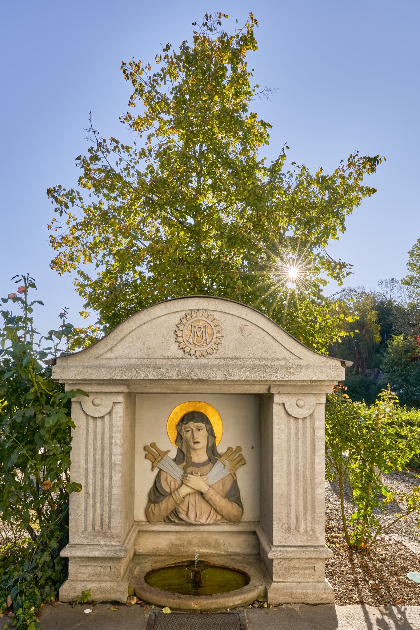 Kronwidl Brunnen, Ecksberg, Mühldorf am Inn, Oberbayern - Kapelle Heilquelle Ecksberg Altmühldorf Kronwidl, Mühldorf. Mühldorf am Inn, Oberbayern, Inn-Salzach, Deutschland. Historische Brunnenanlage, Steinfigur, Grün.