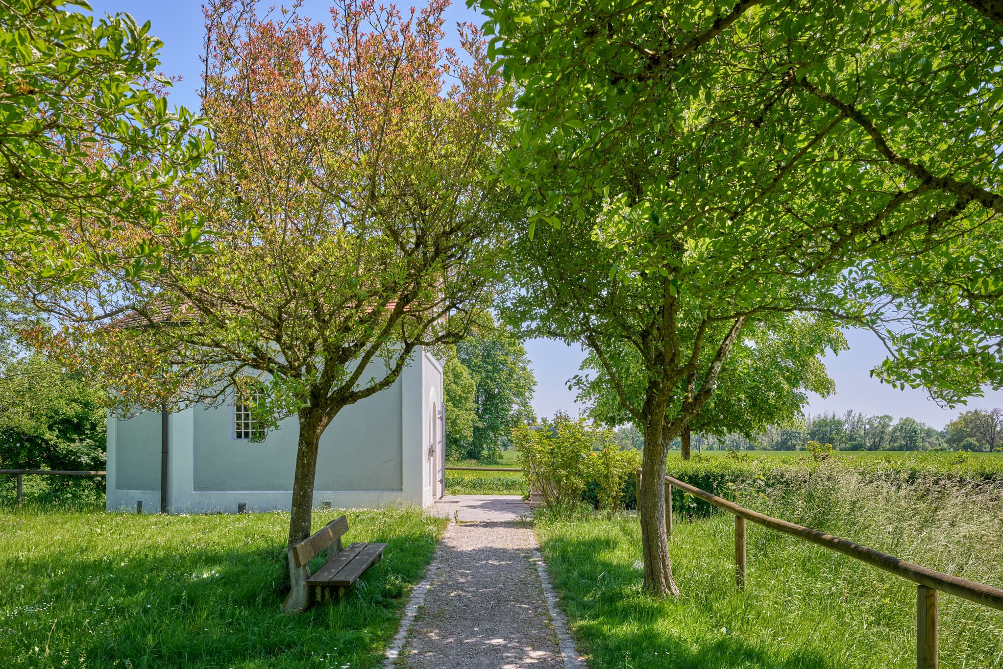 Kronwidl Kapelle, Ecksberg Altmühldorf, Oberbayern - Kronwidl Kapelle in Ecksberg Altmühldorf, Mühldorf am Inn, Oberbayern, Deutschland. Ein Weg führt zur Kapelle, umgeben Bäumen, Bank, grünen Wiesen.