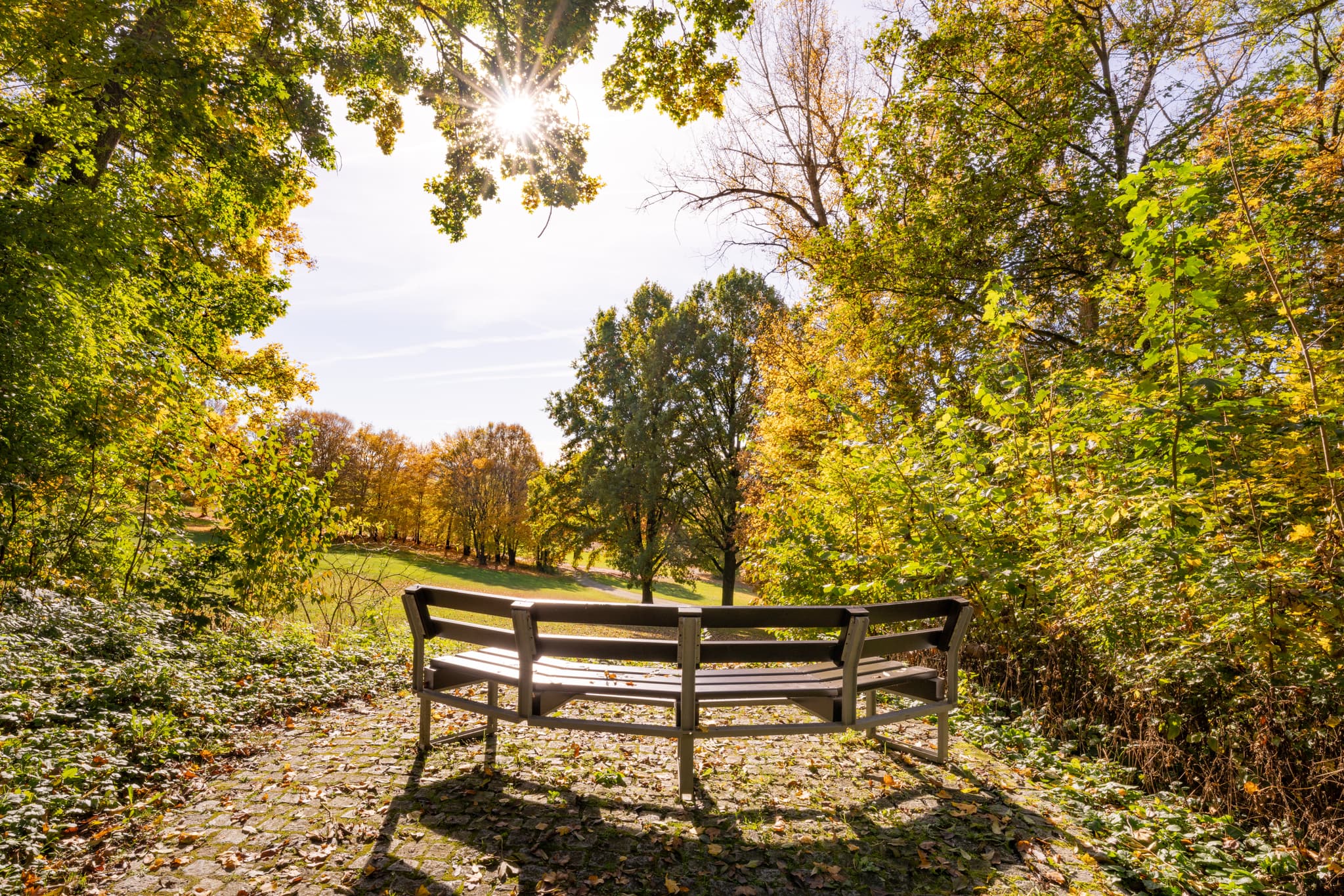 Kurpark in Bad Griesbach, Passau, Niederbayern, Rottal - Herbstliche Impressionen aus dem Kurpark der Therme Bad Griesbach, Passau, Niederbayern. Eine einladende Bank inmitten der bunten Natur im Rottal, Deutschland.