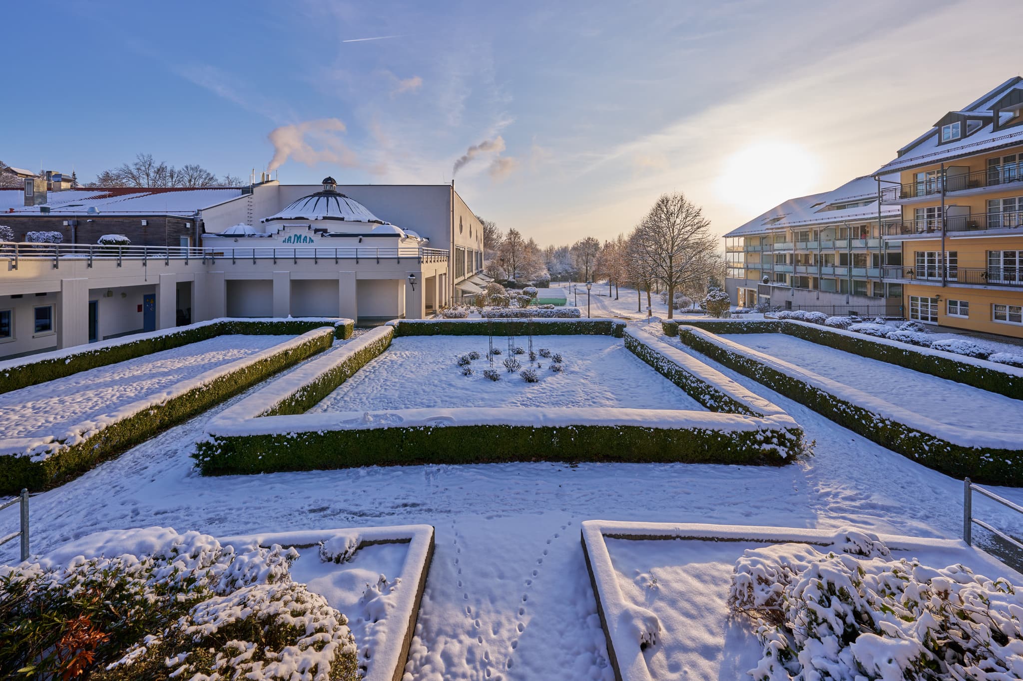Kurplatz Bad Griesbach Winter, Passau, Niederbayern, Rottal - Ein winterlicher Blick auf den Kurplatz in Bad Griesbach im Rottal, Landkreis Passau, Niederbayern. Schnee bedeckt die Anlage unter strahlendem Sonnenschein.