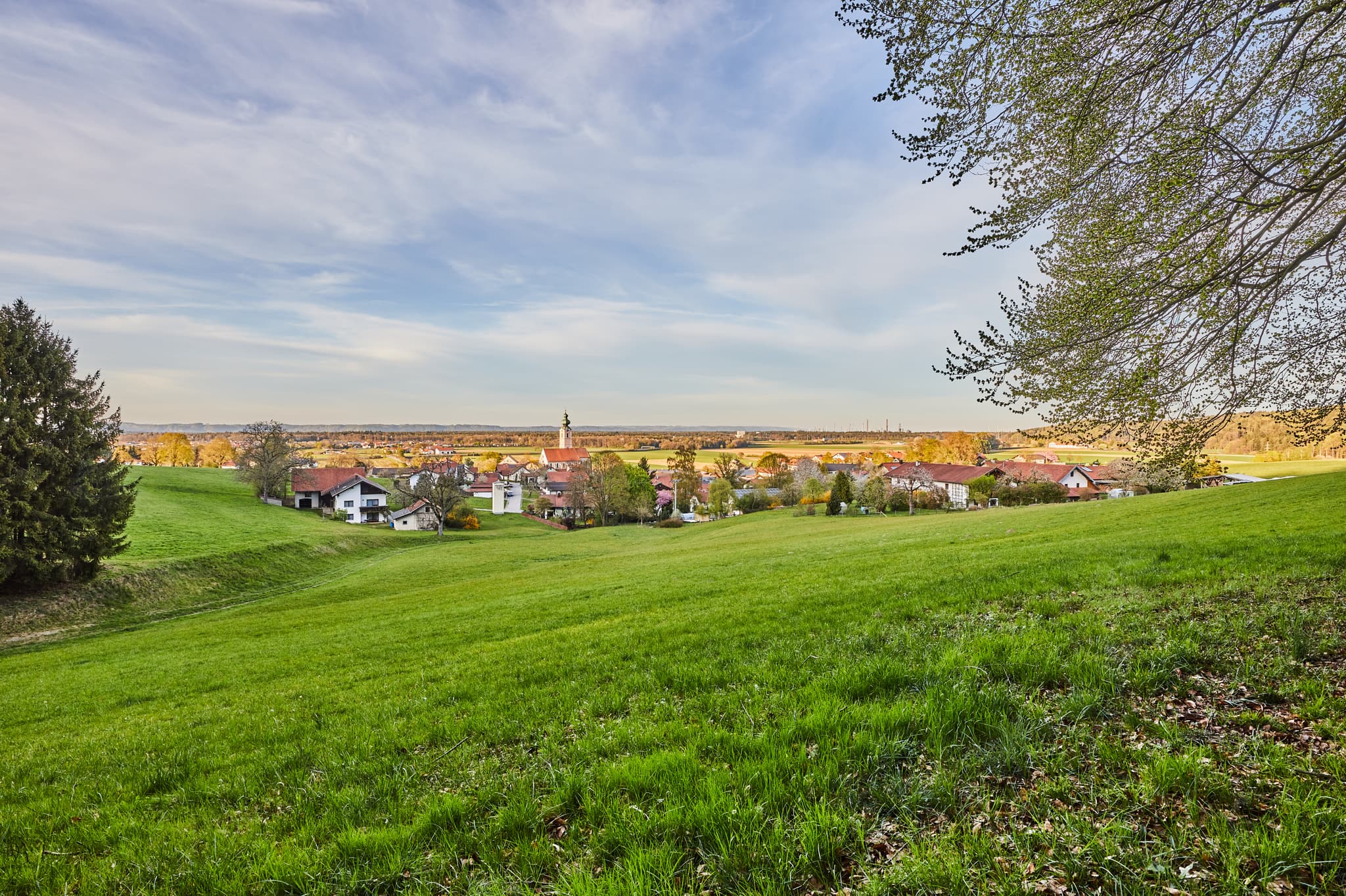 Landschaft mit Ort, Hörndlweg, Altötting, Oberbayern - Idyllische Landschaftsaufnahme vom Hörndlweg in Mehring, Altötting. Die Szene zeigt grüne Wiesen, den Ort und weitläufige Natur in Oberbayern.
