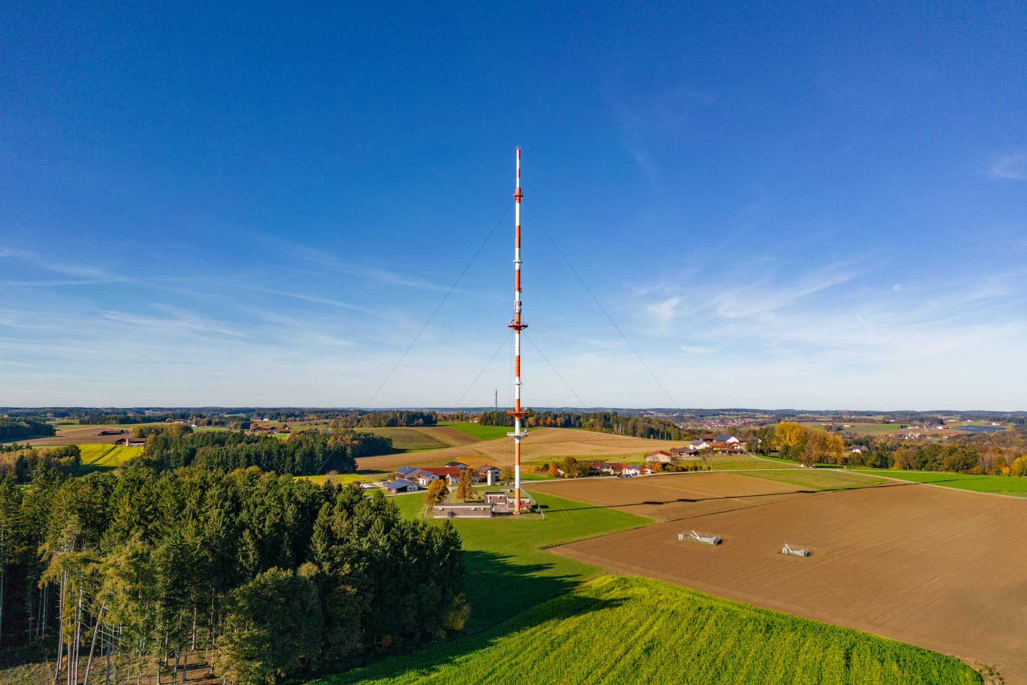 Luftbild Funkturm Rottenstuben, Rottal-Inn, Niederbayern - Funkturm in Rottenstuben, Hebertsfelden, umgeben von Feldern und Wäldern im Landkreis Rottal-Inn, Niederbayern. Das Holzland in Deutschland bei blauem Himmel.