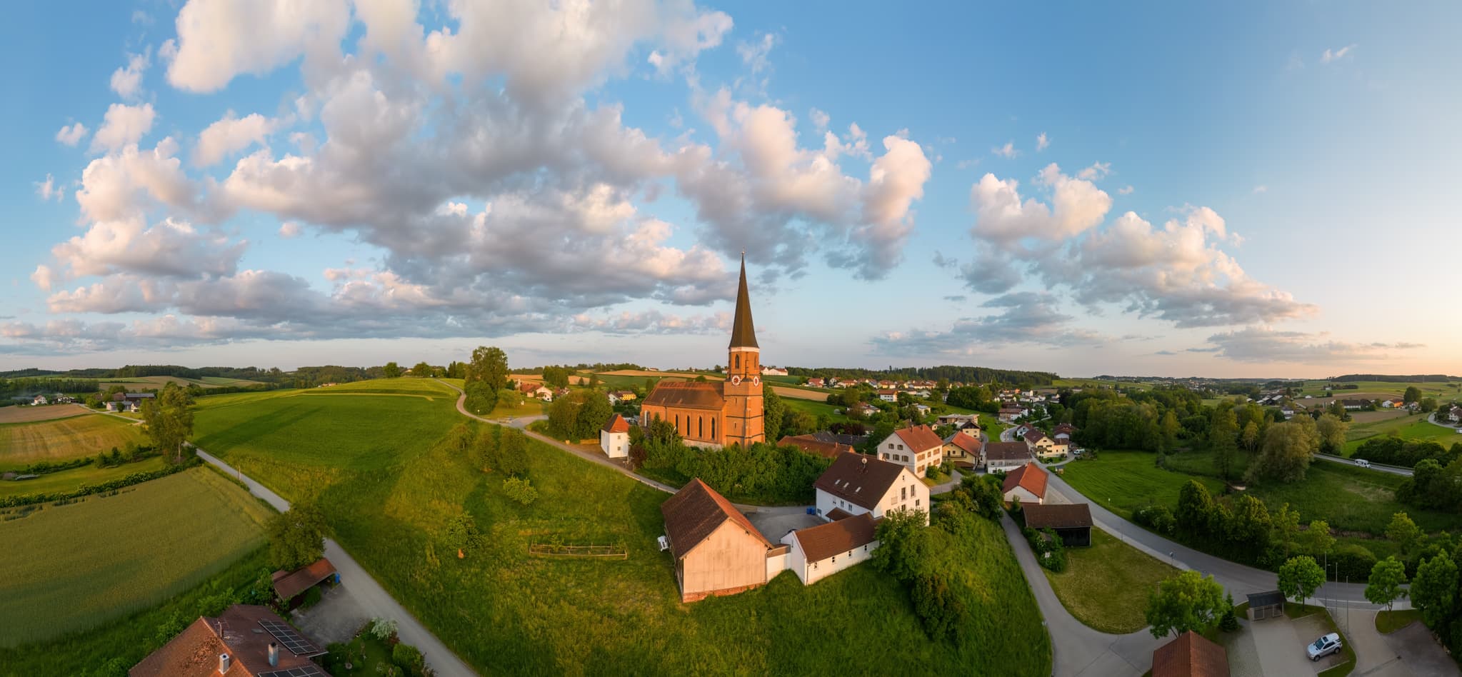 Luftbild mit Pfarrkirche St. Rupert, Hirschhorn, Rottal-Inn - Pfarrkirche St. Rupert in Hirschhorn, Wurmannsquick, Rottal-Inn, Niederbayern. Ländliche Szenerie im Holzland, Deutschland, mit Feldern und Häusern.