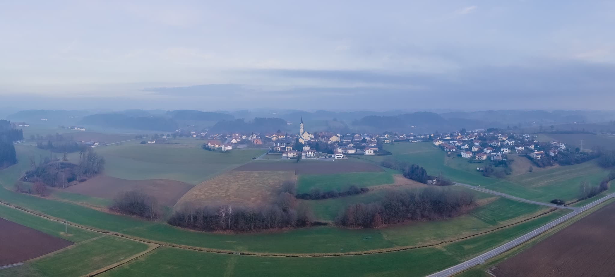 Luftbild Panorama, Pleiskirchen, Landkreis Altötting - Panoramablick auf Pleiskirchen im Landkreis Altötting, Oberbayern, Deutschland. Die Ortschaft liegt in der Inn-Salzach Region, umgeben von Feldern und Wäldern.