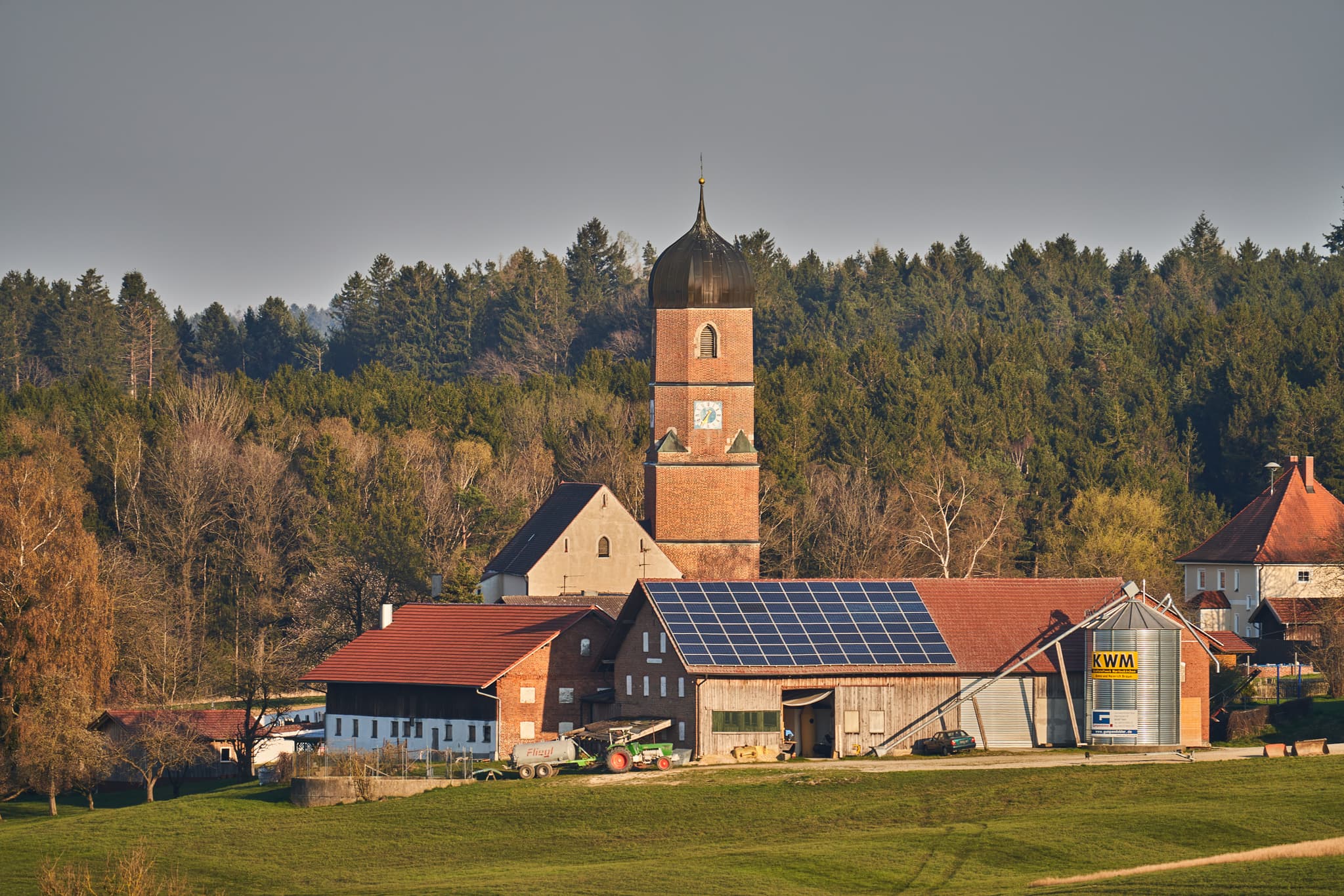 Ort Kirche, Martinskirchen, Rottal-Inn, Niederbayern - Kirche und Bauernhöfe mit Solaranlagen in Martinskirchen, Wurmannsquick, Landkreis Rottal-Inn, Niederbayern. Typische Landschaft des Holzlands, Deutschland.