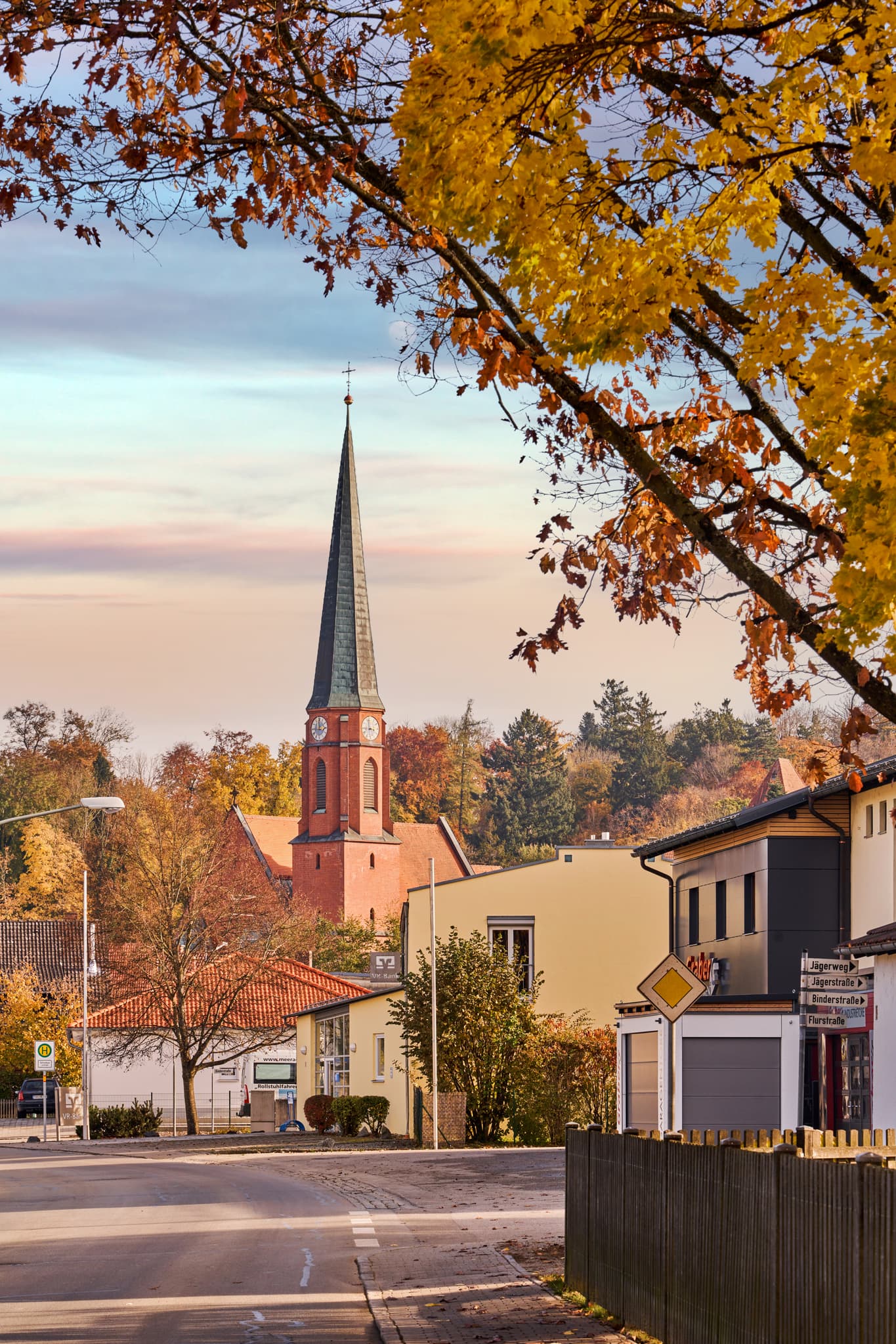 Ortsansicht Hörniweg, Schönau, Rottal-Inn, Niederbayern - Blick auf die Dorfkirche mit markantem Turm und herbstlich gefärbten Bäumen am Hörniweg in Schönau, Landkreis Rottal-Inn, Niederbayern.