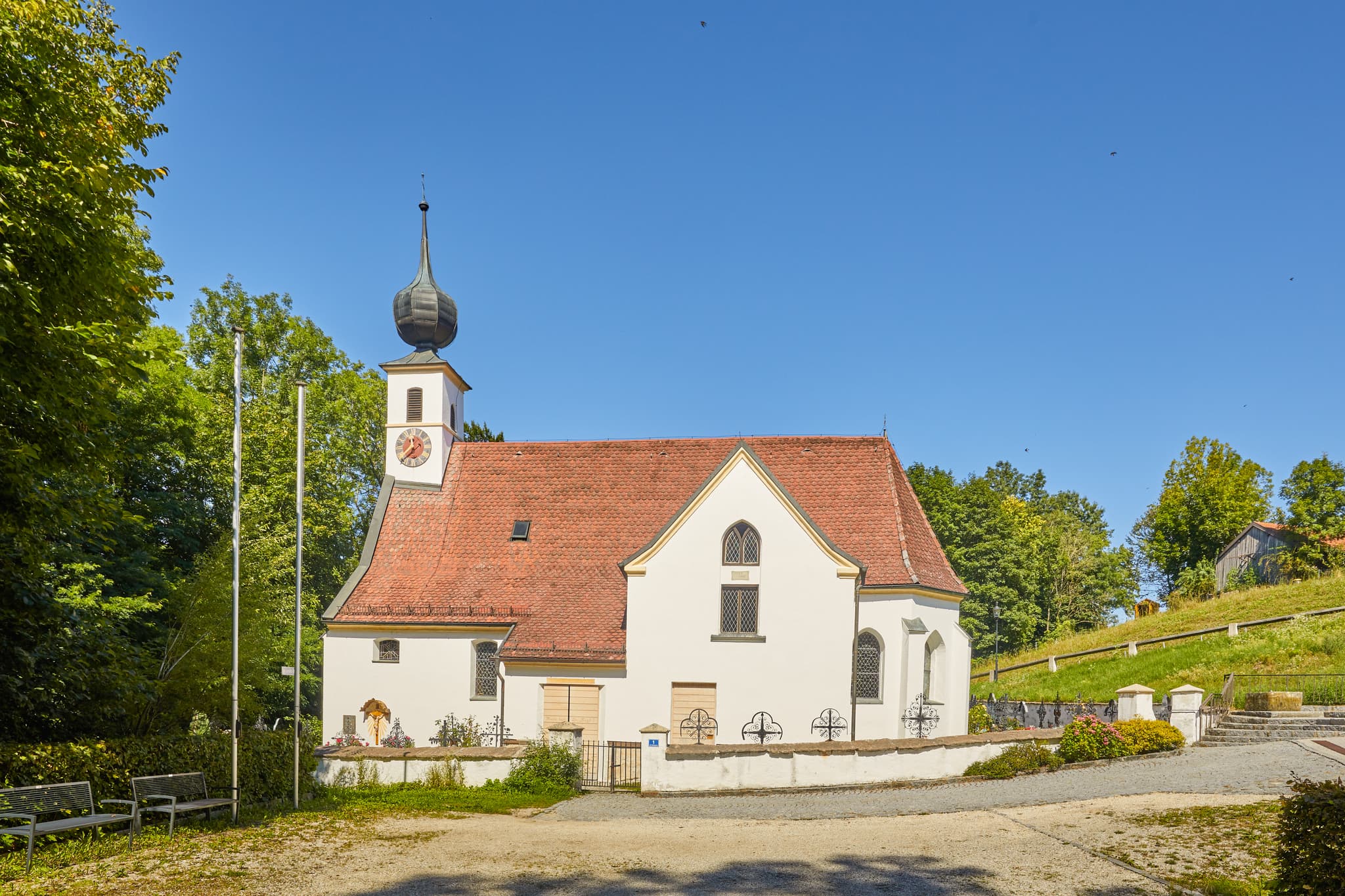Pfarrkirche Radegundis, Hadermarkt, Braunau am Inn - Pfarrkirche Radegundis in Hadermarkt, St. Radegund, Braunau am Inn, Oberösterreich, Innviertel, Österreich. Kirchengebäude in grüner Landschaft.