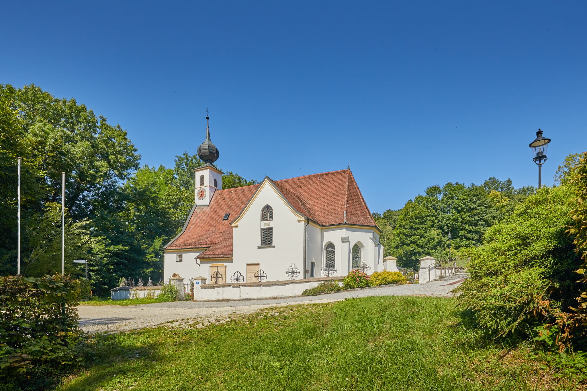 Pfarrkirche Radegundis, Hadermarkt, Braunau am Inn - Pfarrkirche Radegundis in Hadermarkt, St. Radegund, Braunau am Inn, Oberösterreich, Innviertel, Österreich. Kirchengebäude in grüner Landschaft.