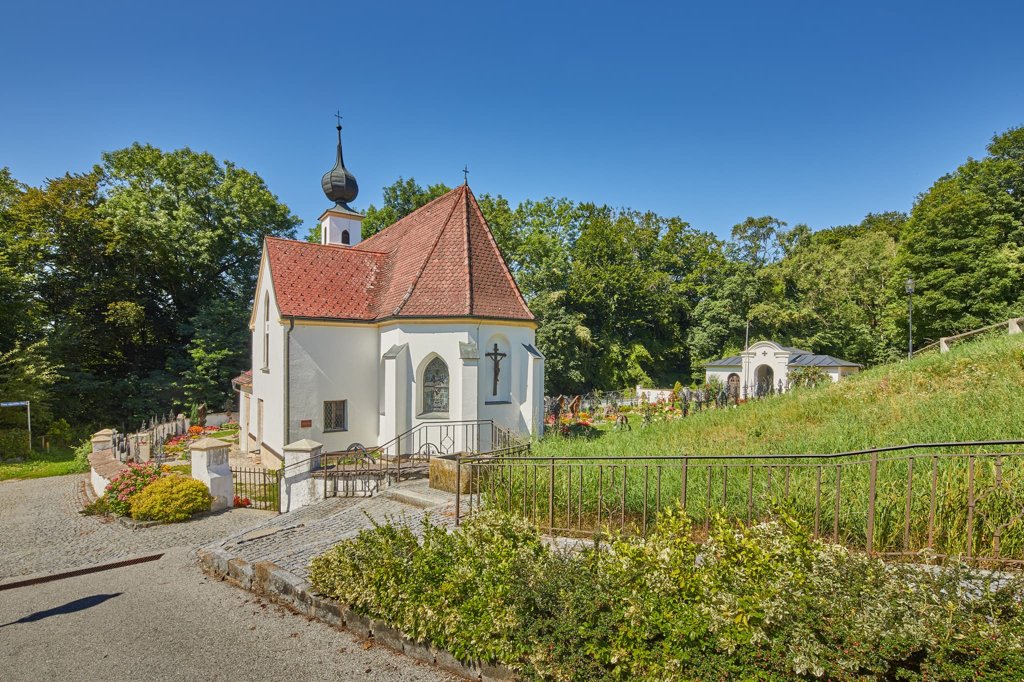 Pfarrkirche Radegundis, Hadermarkt, Braunau am Inn - Pfarrkirche Radegundis in Hadermarkt, St. Radegund, Braunau am Inn, Oberösterreich, Innviertel, Österreich. Kirchengebäude in grüner Landschaft.